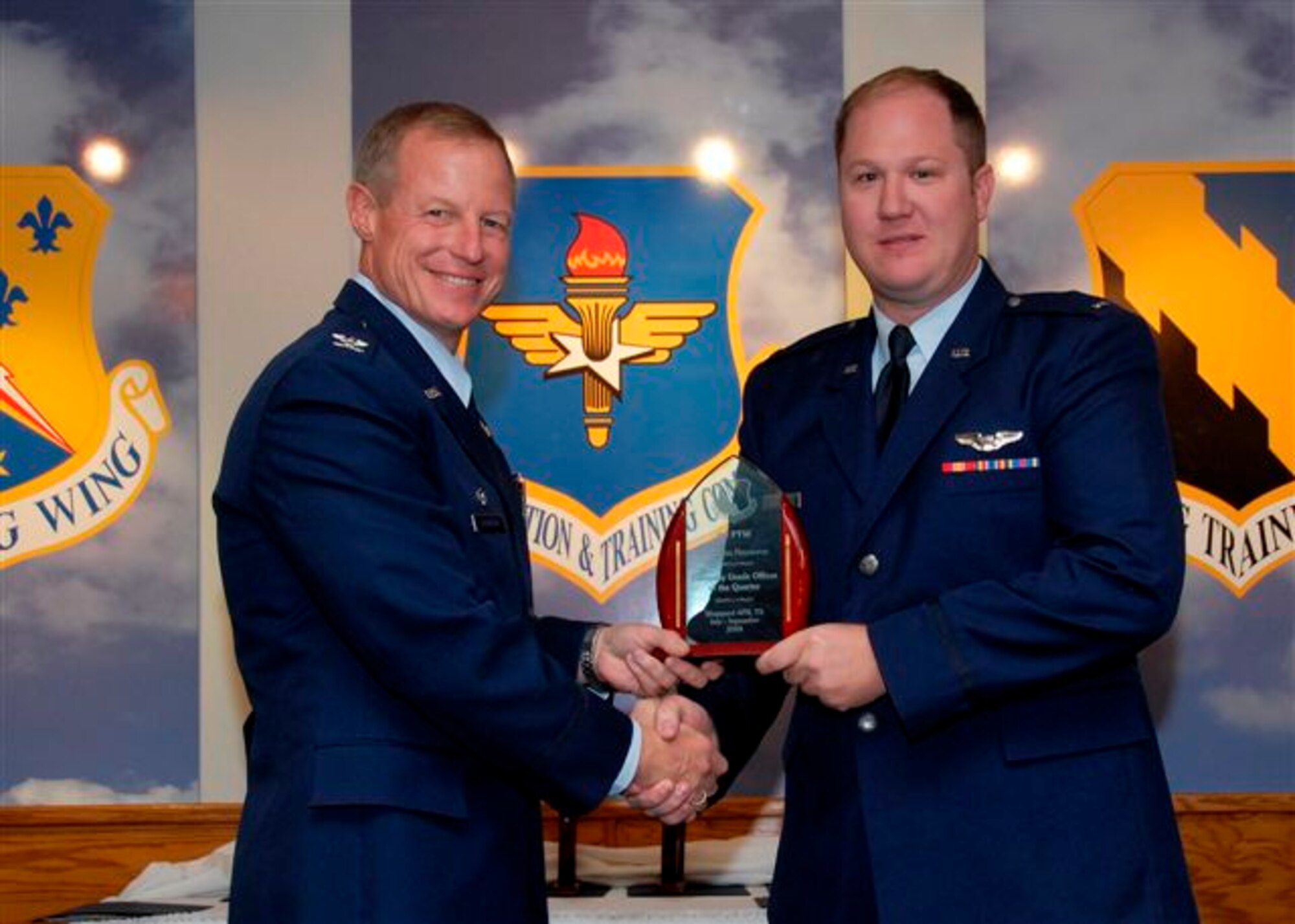 Col. David Petersen, 80th Flying Training Wing commander, presents 1st Lt. Miles Newsome, 80th Operations Support Squadron, with the Company Grade Officer of the Quarter award at the wing quarterly awards ceremony Oct. 21. (U.S. Air Force photo)