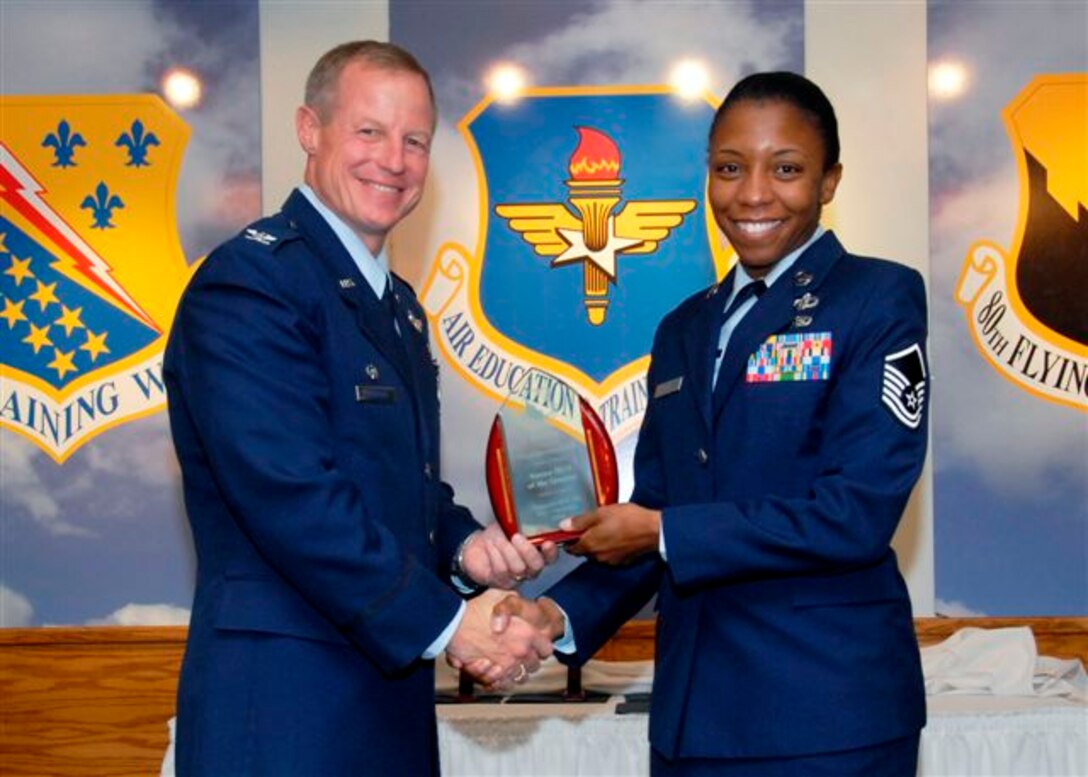 Master Sgt. Veronica Eddie, 80th Operations Support Squadron, accepts the Senior NCO of the Quarter award from 80th Flying Training Wing commander Col. David Petersen at the wing quarterly awards ceremony Oct. 21. (U.S. Air Force photo)