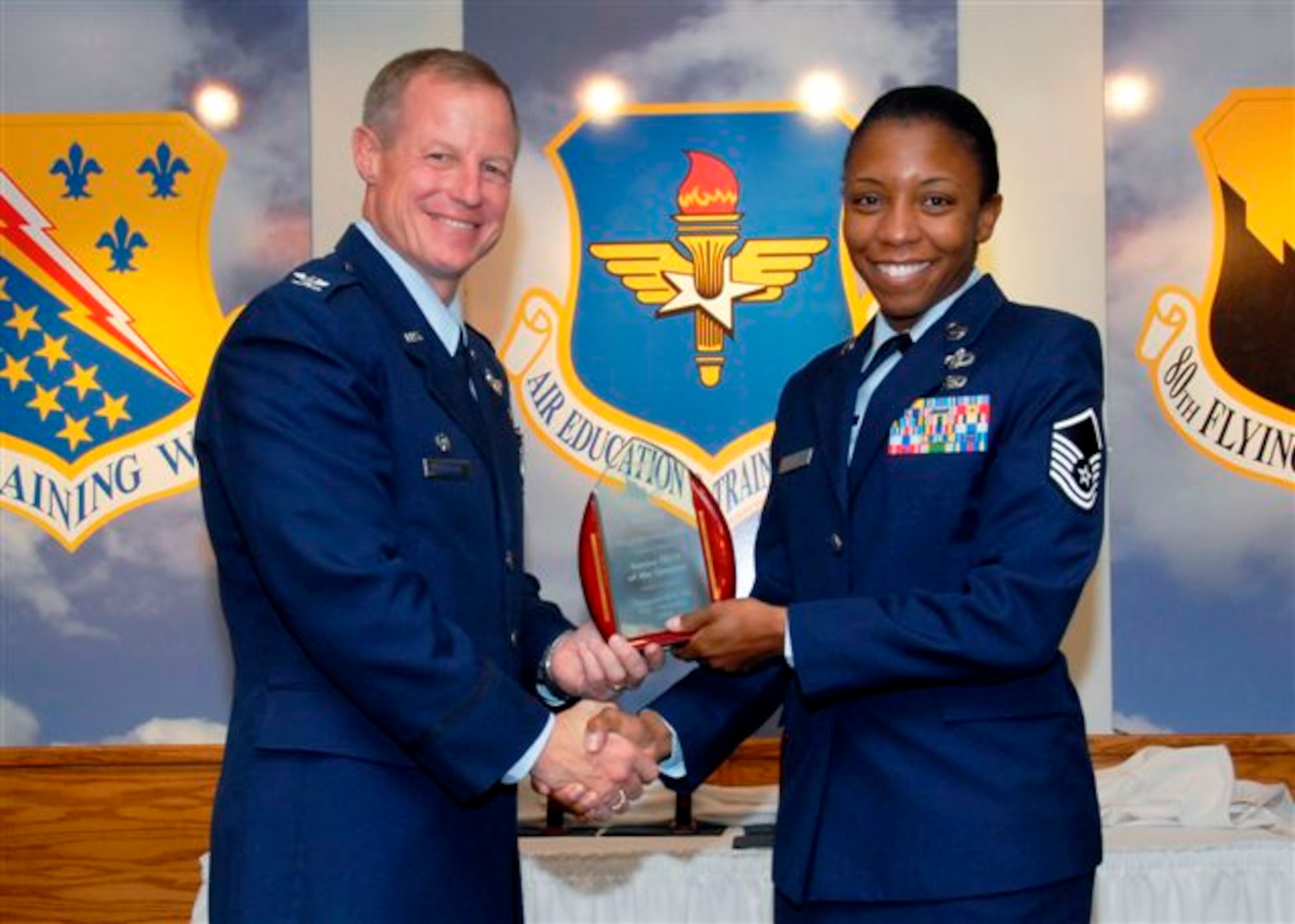 Master Sgt. Veronica Eddie, 80th Operations Support Squadron, accepts the Senior NCO of the Quarter award from 80th Flying Training Wing commander Col. David Petersen at the wing quarterly awards ceremony Oct. 21. (U.S. Air Force photo)