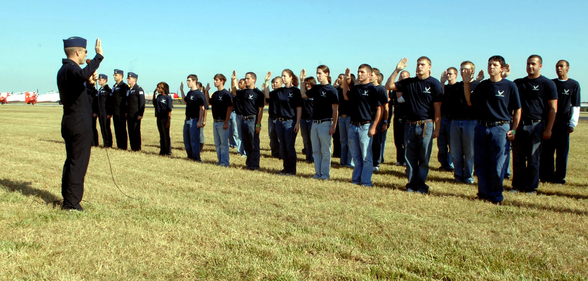 U.S. Air Force Thunderbirds pilot, Lt. Col. Greg Thomas, administers the oath of enlistment for 30 new members of the 331st Recruiting Squadron Delayed Entry Program during a swearing in ceremony Nov. 1, at the Sertoma Cajun Air Show Festival in Lafayette, La. Lt. Col. Thomas is the commander of the U.S. Air Force Air Demonstration Squadron "Thunderbirds" and flies the No. 1 jet. The air show drew more than 240,000 air show enthusiasts. (U.S. Air Force photo)