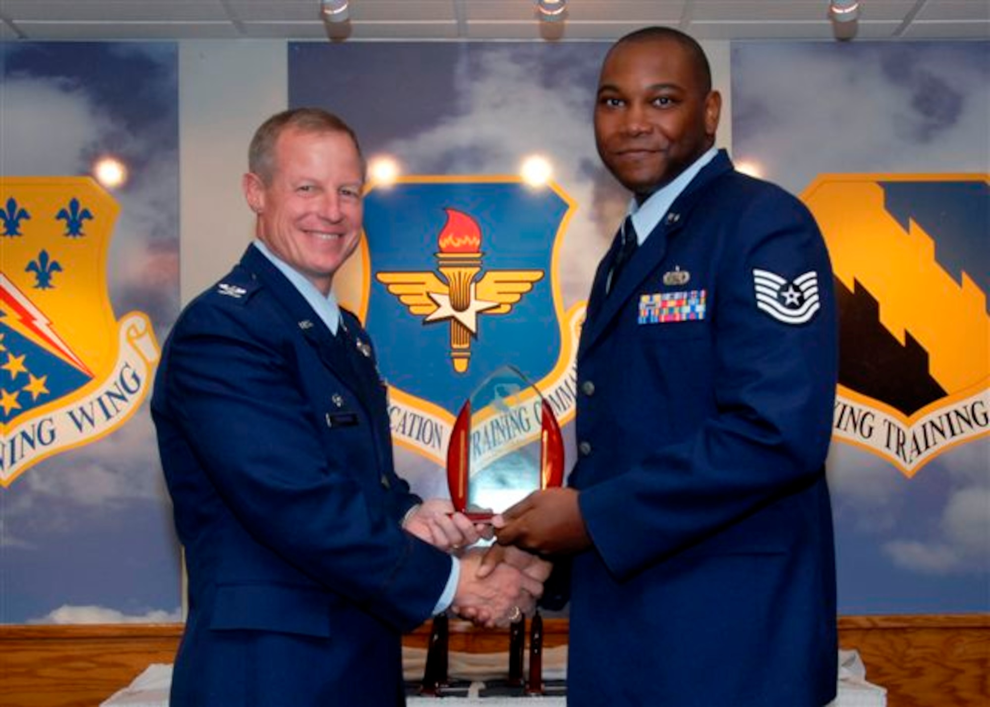 Tech. Sgt. Kenyun Willis, 80th Flying Training Wing, accepts the  NCO of the Quarter award from 80th Flying Training Wing commander Col. David Petersen at the wing quarterly awards ceremony Oct. 21. (U.S. Air Force photo)