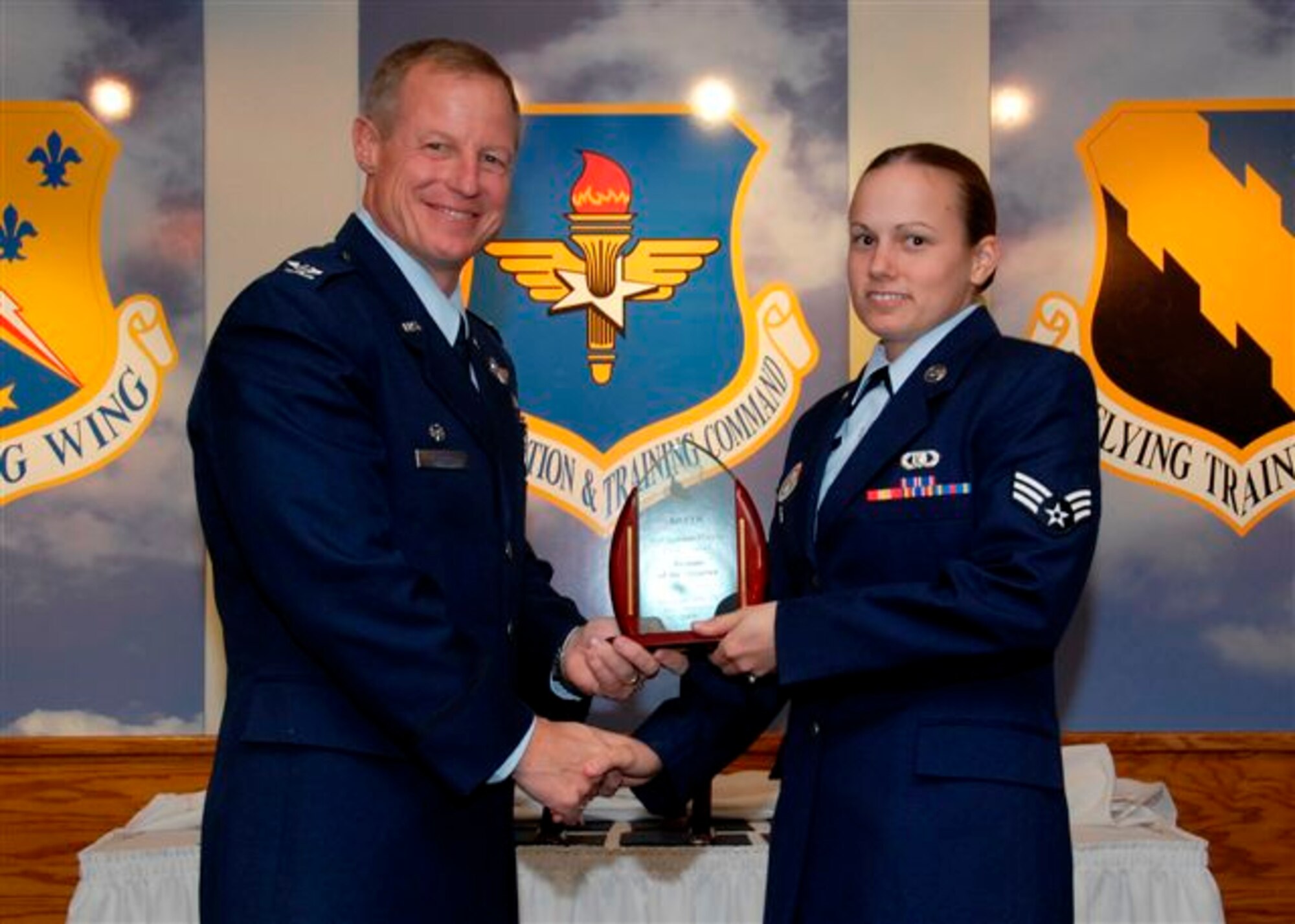 Senior Airman Siobhan McMullen, 80th Operation Support Squadron, accepts the  Airman of the Quarter award from 80th Flying Training Wing commander Col. David Petersen at the wing quarterly award ceremony Oct. 21. (U.S. Air Force photo)