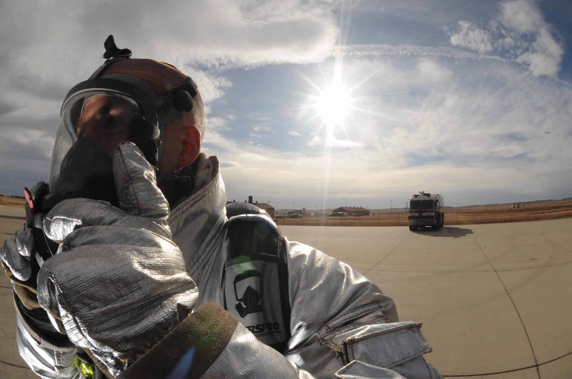 Staff Sgt. Maynard Depew, 28th Civil Engineer Squadron firefighter crew chief, latches his mask during pit fire training held here, Nov. 4. To comply with Federal Aviation Administration annual training requirements training burns are conducted regularly, to ensure Ellsworth firefighters maintain their readiness.  (U.S. Air Force photo/ Airman 1st Adam Grant)