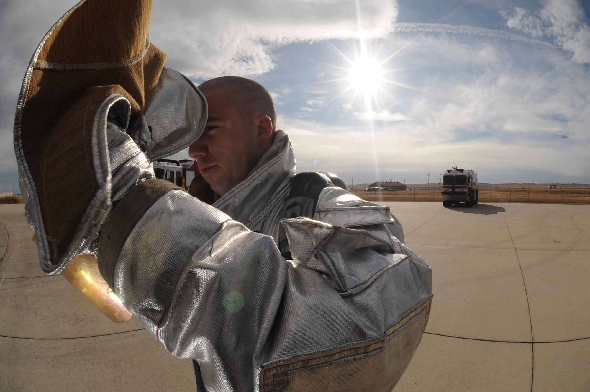 Staff Sgt. Maynard Depew, 28th Civil Engineer Squadron firefighter crew chief, puts his helmet on while in preparation for pit fire training here, Nov. 4. Training burns are conducted regularly to ensure Ellsworth firefighters maintain readiness and meet Federal Aviation Administration annual training requirements. (U.S. Air Force photo/ Airman 1st Adam Grant)