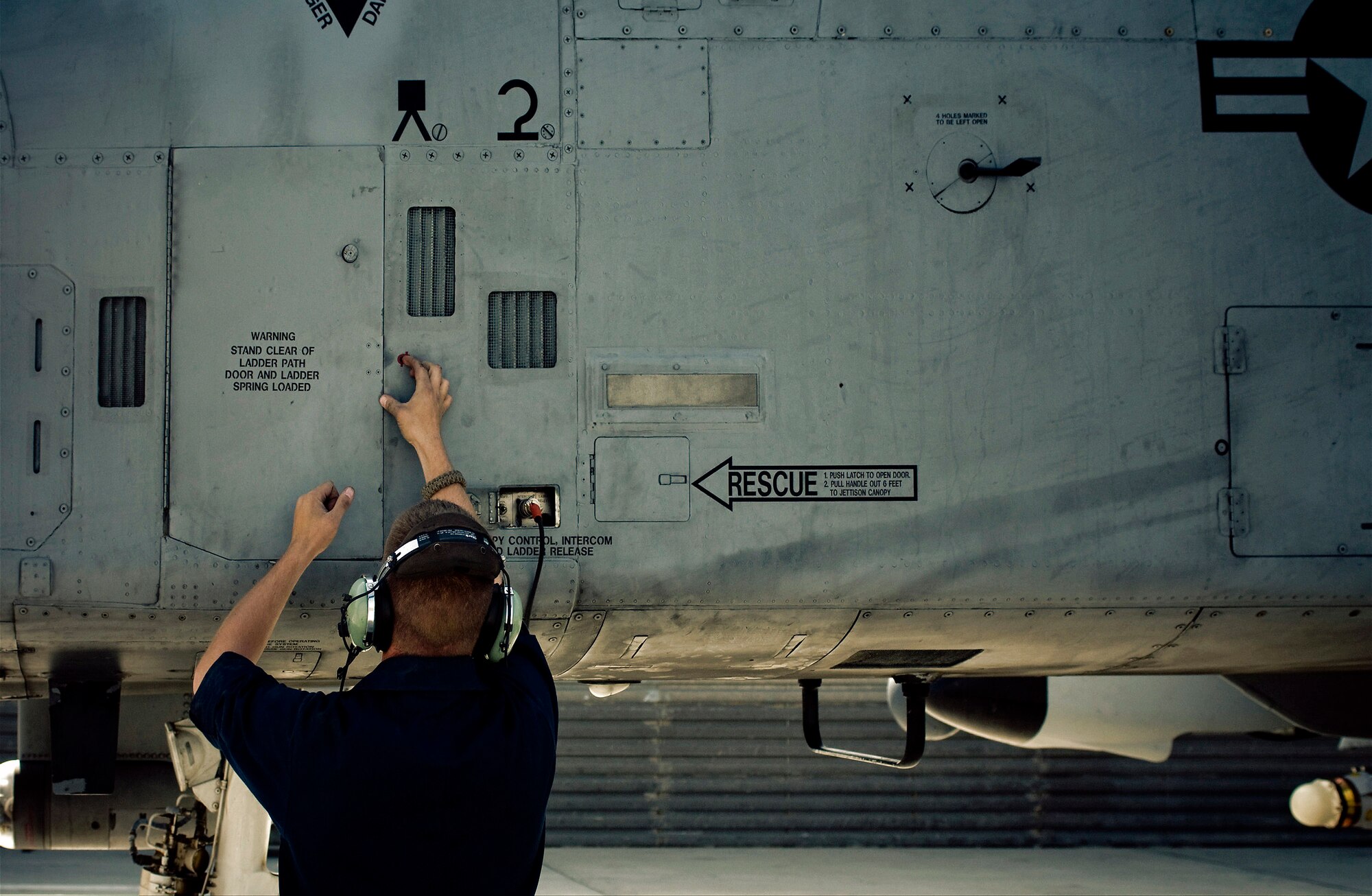 Senior Airman Benjamin Connery closes the crew boarding ladder door and disconnects his headset from the communications port of a A-10 Thunderbolt II Oct. 18 at Bagram Airfield, Afghanistan. Both crew chief and pilot stay in constant communication throughout the preflight inspections allowing the crew chief to be the pilot's eyes and ears outside the aircraft. Airman Connery is a 455th Expeditionary Aircraft Maintenance Squadron A-10 crew chief and deployed from Moody Air Force Base, Ga. He is from Cashmere, Wash. (U.S. Air Force photo/Staff Sgt. Samuel Morse) 