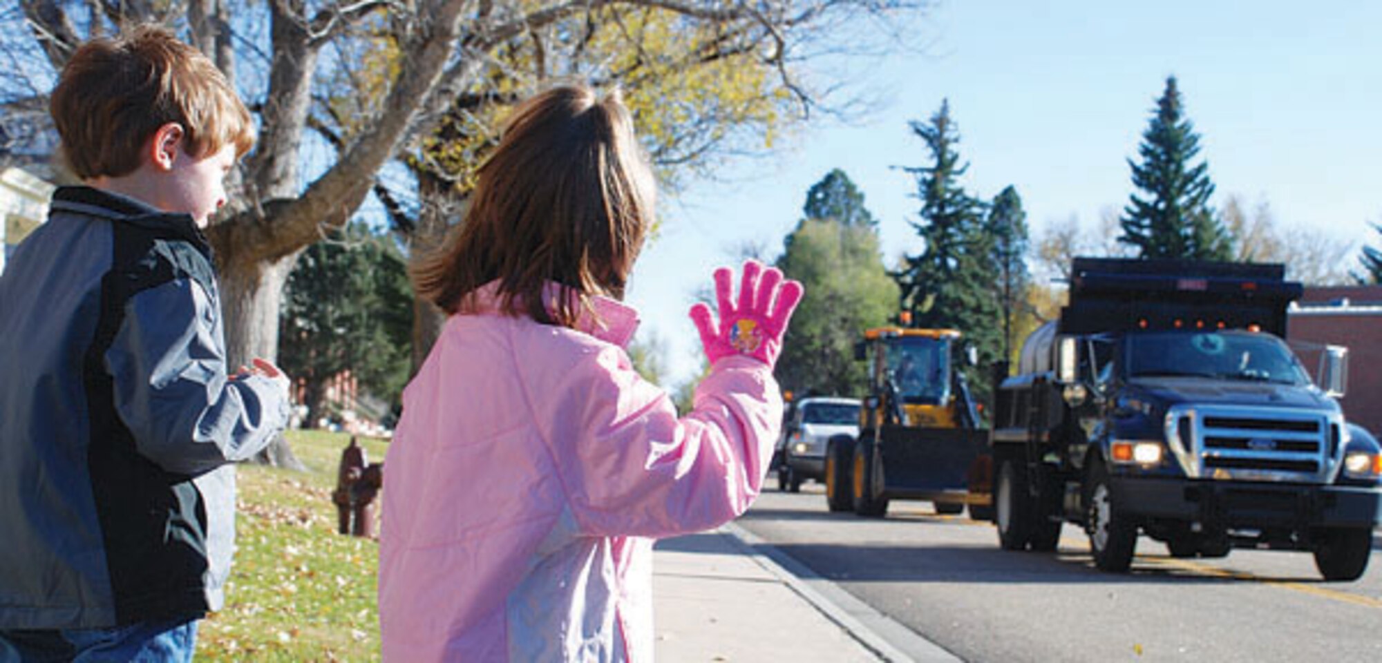 Austin and Emilee Phillips, children of the 90th Force Support Squadron Commander Lt. Col. Todd Phillips, wait outside to greet the oncoming Snow Parade traffic in hopes of catching candy that was thrown out during the route. (Photos by 2nd Lt Brooke Brzozowske)