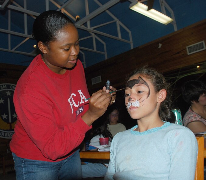 SOTO CANO AIR BASE, Honduras - Air Force Staff Sgt. Davida Kun volunteers to paint faces during a base-wide sponsored orphanage day for Halloween Nov. 1. More than 120 children from Joint Task Force-Bravo sponsored orphanages took part in activities ranging from a haunted house, face painting, soccer, and free food. Sergeant Kun is deployed from Dyess Air Force Base, Texas. (U.S. Air Force photo by Staff Sgt. Joel Mease)