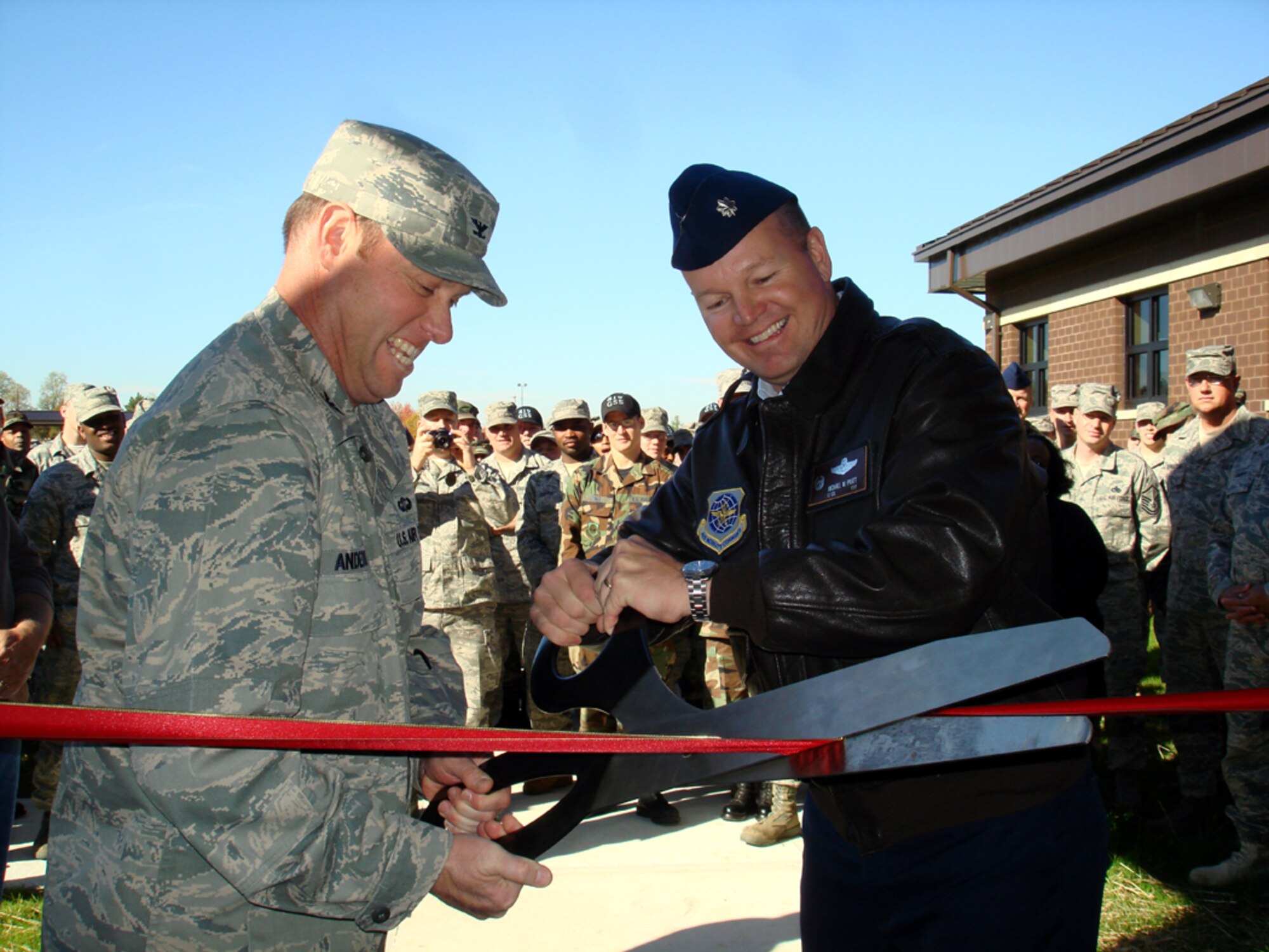 Left, Col. Richard Anderson, 621st Contingency Response Wing vice commander and Lt. Col. Michael Pratt, 819th Global Support Squadron commander, cut the ribbon during the inauguration ceremony of Building 3422 Oct. 31. The new building will accommodate the 189th GSS command support staff and training flight personnel.  The building will serve as the primary location for several training requirements, including classroom instruction for the entire 621st Contingency Response Wing. The building is located in the Global Reach Deployment Center compound on Broidy Road. (U.S. Air Force photo/Staff Sgt. Francis Lalic) 