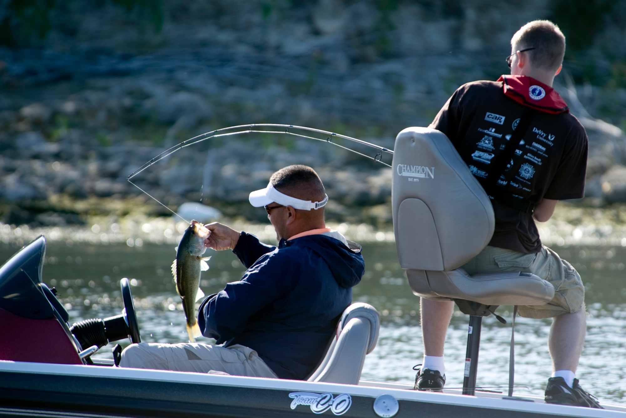 Tech. Sgt Chuck Bunch (left) retrieves a bass caught by Senior Airman Marcus Creason during Fishing for Freedom V held Oct. 25 at Choke Canyon, Texas. Thirty-three injured servicemembers participated in the event. Sergeant Bunch and Airman Creason finished the competition with their largest fish weighing 3 pounds, 1 ounce. (U.S. Air Force photo/Master Sgt. Jack Braden)