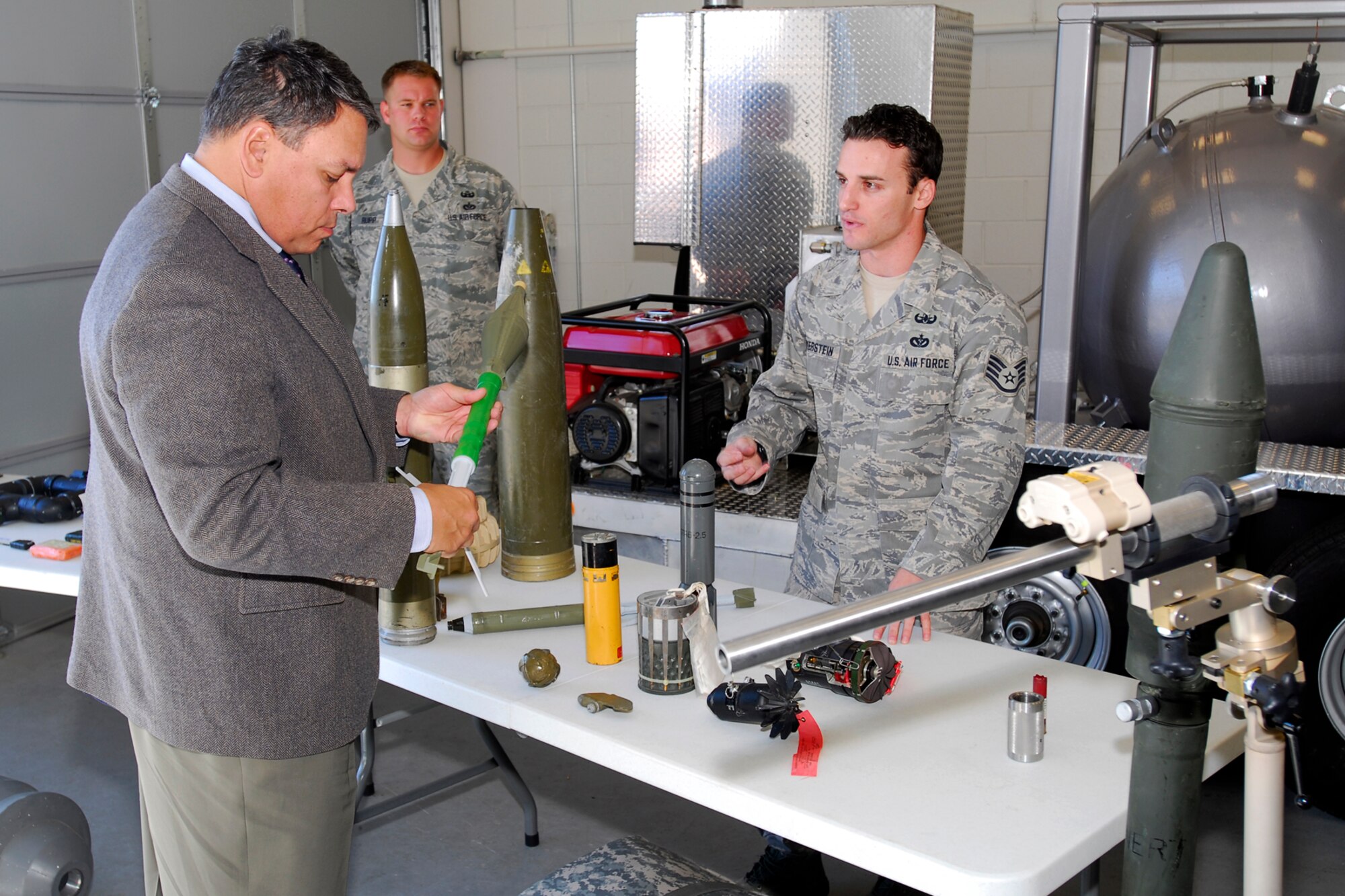 Staff Sgt. Layne Mayerstein, 21st Civil Engineer Squadron Explosive Ordnance Disposal Section, a veteran of four Iraq/Afganistan tours, shows various types of ordnances found in the Middle East toThe Honorable Kevin Billings, acting assistant secretary of the Air Force for installations, environment and logistics, during his Oct. 28 visit to Peterson AFB . (Air Force photo/Rob Lingley)