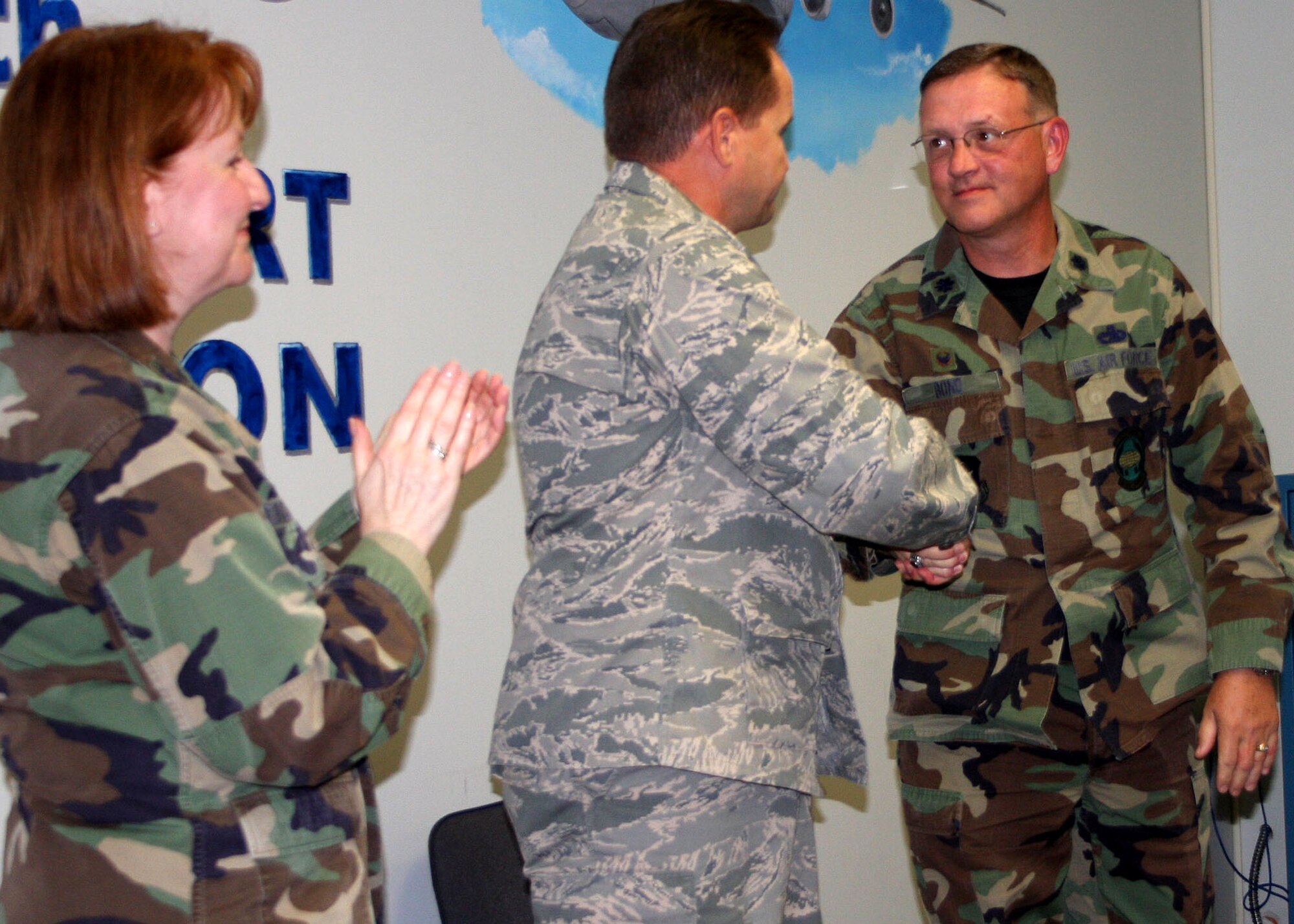 WRIGHT-PATTERSON AFB, Ohio - Maj. David Mohr, incoming 87th Aerial Port Squadron commander,  and Lt. Col. Keith Bond, outgoing commander shake hands during the 87th Aerial Port Squadron Change of Command ceremony as Col Mary Henderhan, 445th Mission Support Group commander, claps. (Air Force photo/Maj. Jose Cardenas)  