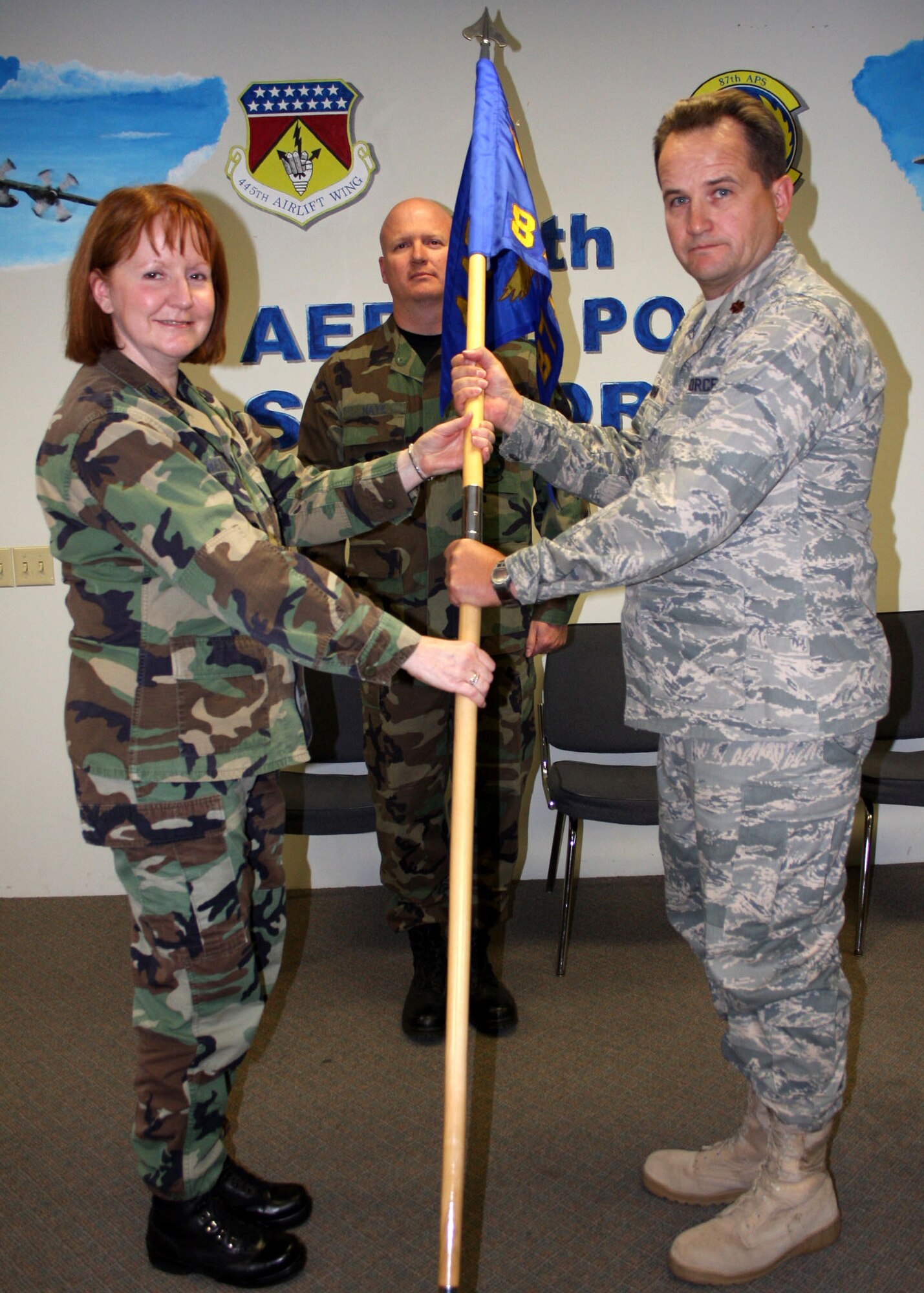 WRIGHT-PATTERSON AFB, Ohio - Col. Mary Henderhan, 445th Mission Support Group commander, passes the guidon to Maj. David Mohr, incoming 87th Aerial Port Squadron commander, during the Change of Command ceremony as Senior Master Sgt. Robert Haye looks on. (Air Force photo/Maj. Jose Cardenas)  