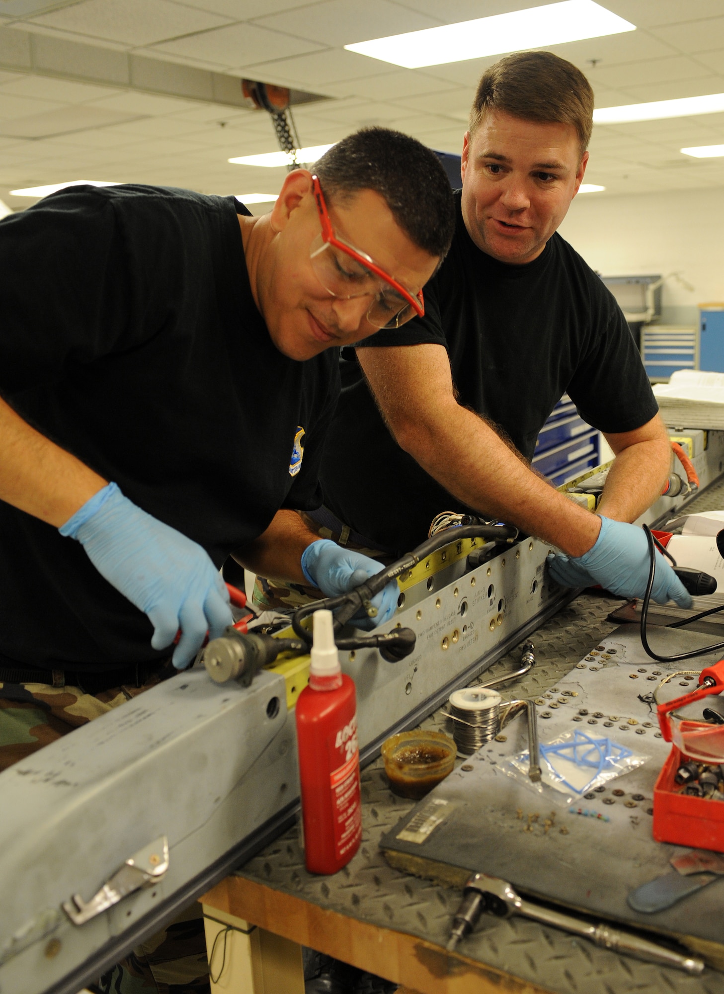 LANGLEY AIR FORCE BASE, Va. – Tech. Sgt. Thomas Moore and Staff Sgt. Jasen Hendricksen, 192nd Air National Guard armament systems craftsmen, perform maintenance of a LAU-128 missile launcher.   Sergeants Moore and Henderson work in the 1st Equipment Maintenance Squadron armament flight.  The armament flight inspects equipment that is installed on both the F-15 and F-22. Each piece of equipment carries and fires missiles or ammunition.  (U.S. Air Force Photo/Airman 1st Class Zachary Wolf)