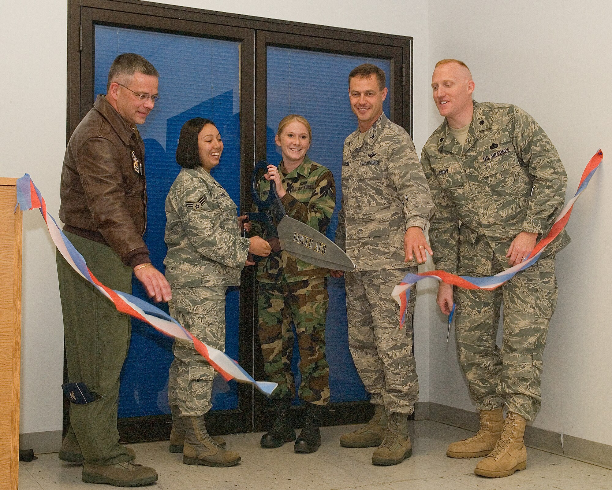 (From left) Col. Randal Bright, 512th Airlift Wing commander; Senior Airman Vanessa Novian, 436th Communications Squadron network administrator; Senior Airman Krystal Miller, 436th CS Personal Wireless Communications Systems manager; Col. Steven Harrison, 436th AW commander; and Lt. Col. Brian Eddy, 436th Services Squadron commander, cut the ribbon on the new Airmans Outpost in the Eagle Lanes and Recreation Center.  The Airmans Outpost has a large screen tv, video games and a pool table.  (U.S. Air Force photo/Thomas Randle)

