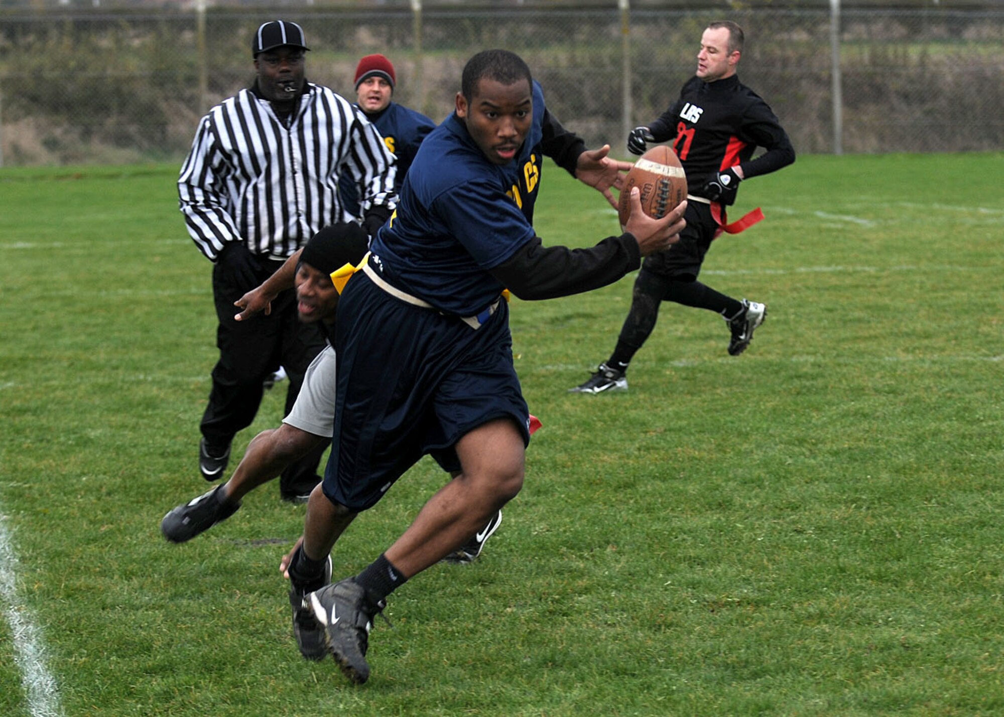 Christopher Bourand, 100th Communications Squadron, slips by Christopher Williams from the 100th Logistics Readiness Squadron during the flag football championship game Nov. 1, 2008, at RAF Mildenhall, England. The communications squadron defeated the logistics readiness squadron with a 1 point victory with the final score of 14-13. (U.S. Air Force photo by Staff Sgt. Jerry Fleshman)