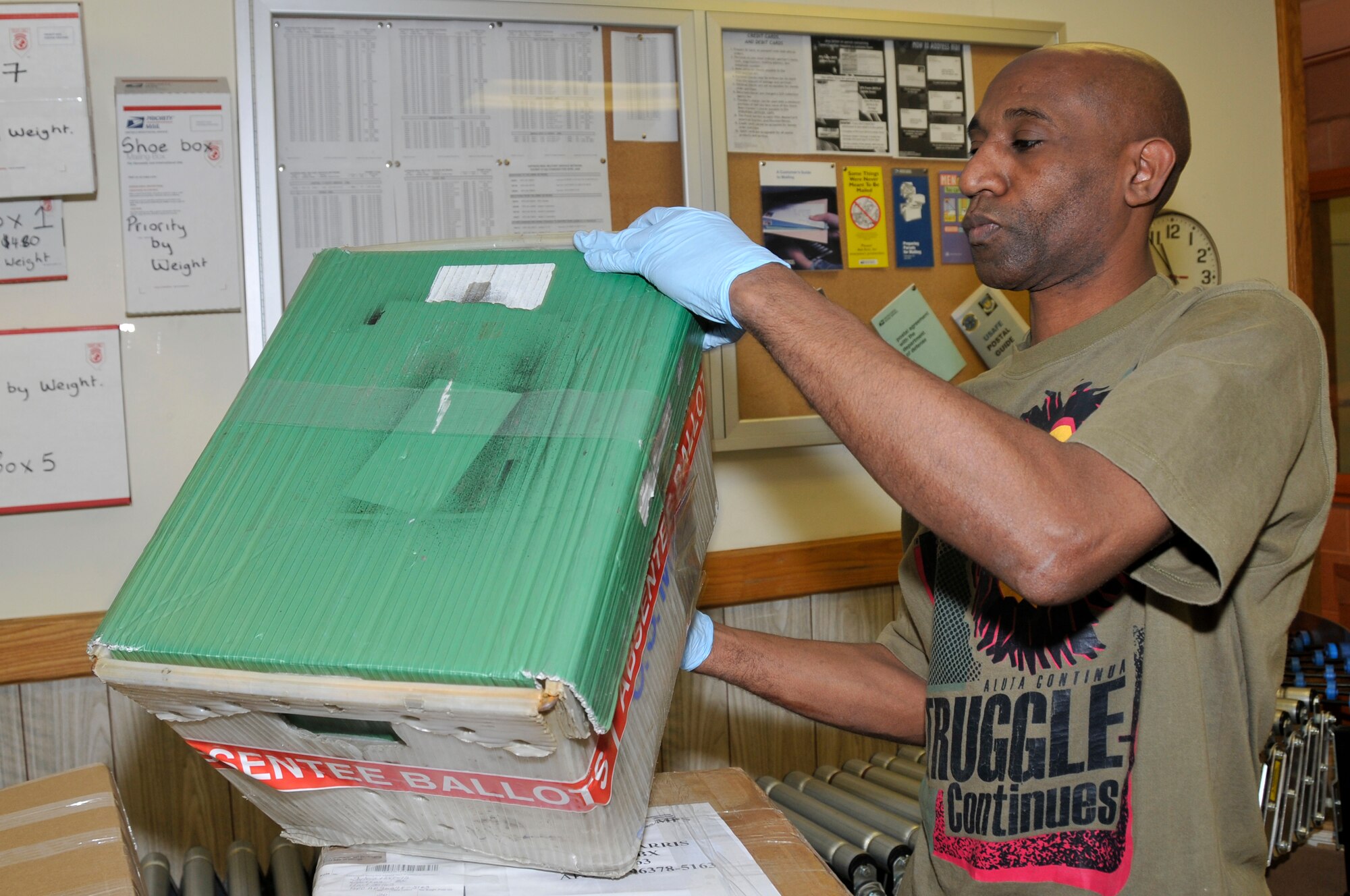 Derrick Foster, 48th Communications Squadron supervisor of receiving and dispatch, secures the lid on a mail box filled with ballots to be sent out Oct. 29 at RAF Lakenheath, England. Customers can have their ballots mailed via Express mail 3-day service, free of charge. (U.S. Air Force photo by Airman 1st Class Perry Aston)