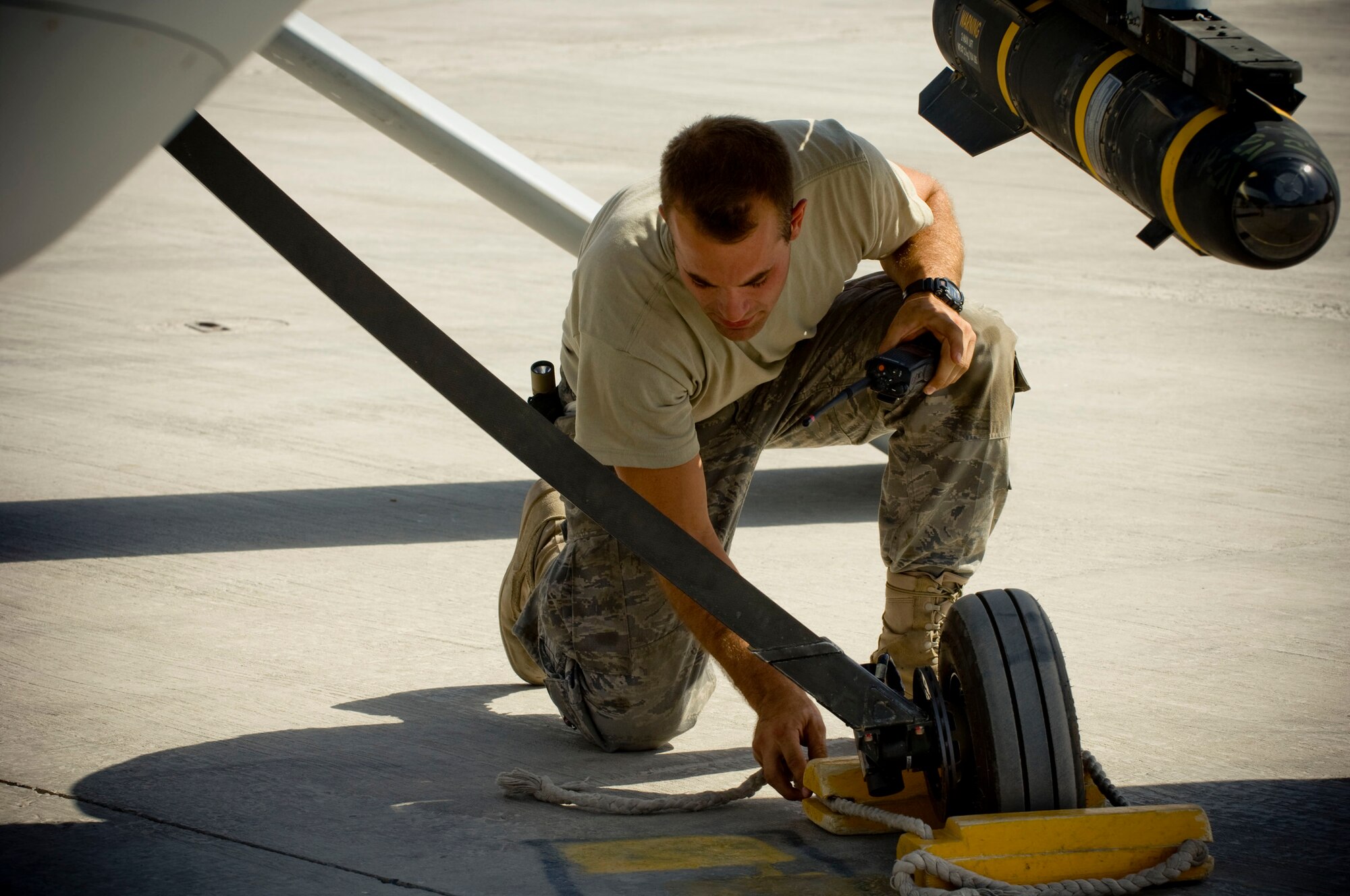 Airman 1st Class Justin Cole, 62nd Expeditionary Reconnaissance Squadron crew chief, removes the chalks of an MQ-1 Predator at a base in southern Afghanistan, Oct. 25. Despite the unmanned, remote nature of the aircraft, they are still treated with all the same precautions and considerations of the larger, manned airframes. Airman Cole is deployed from the 432nd Aircraft Maintenance Squadron, Creech Air Force Base, Nevada, and hails from Orange Park, Fla. (U.S. Air Force photo by Staff Sgt. Samuel Morse/Released)