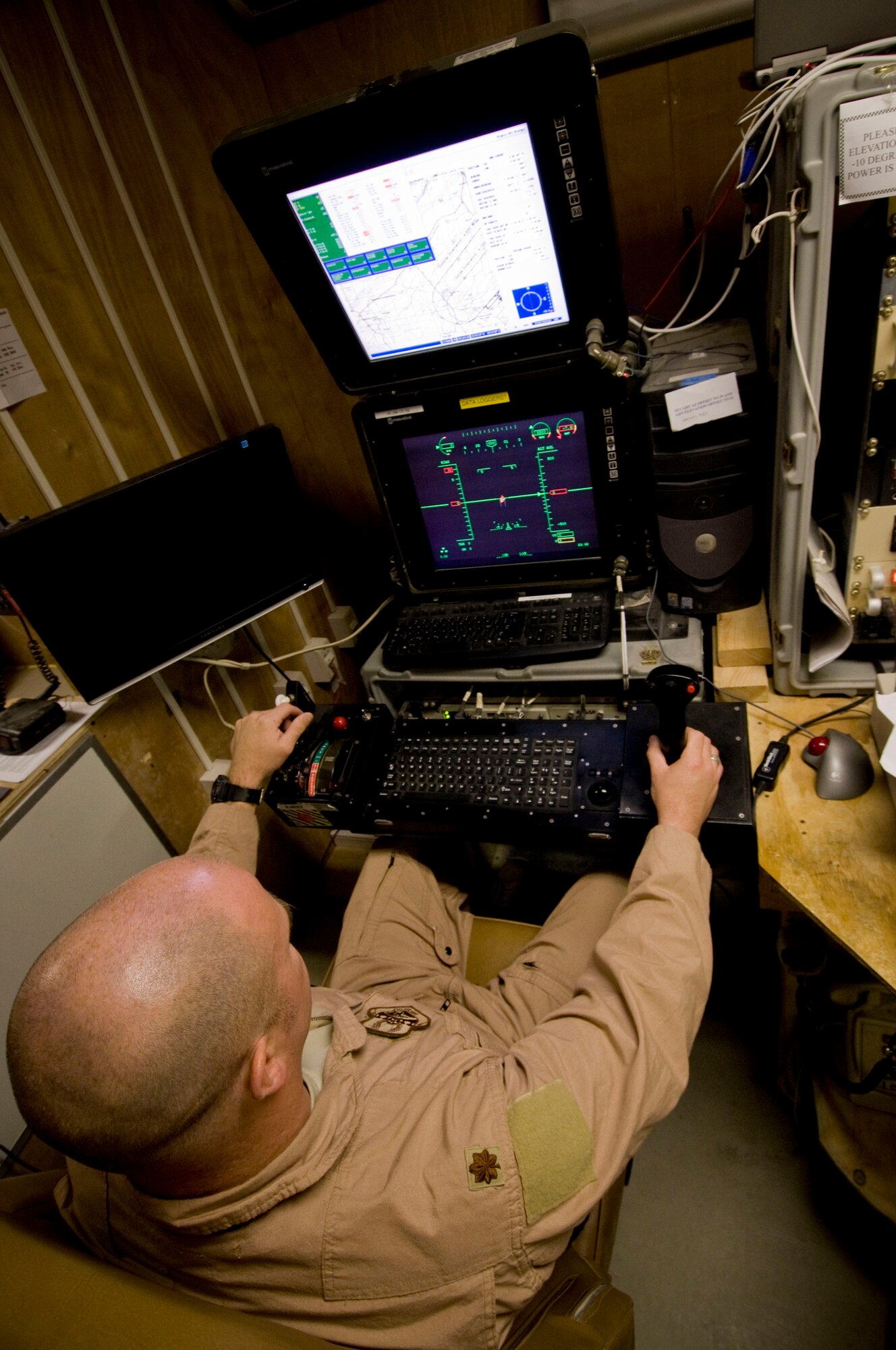 Maj. Rick Wageman, 62nd Expeditionary Reconnaissance Squadron pilot, operates the virtual cockpit of an MQ-1 Predator at a base in southern Afghanistan, Oct. 25. The remote nature of the control allows the Predator to stay airborne for longer periods of time, changing pilots periodically to reduce stress and fatigue which can lead to mission failure. Major Wageman is deployed from Cannon Air Force Base, N.M. (U.S. Air Force photo by Staff Sgt. Samuel Morse/Released)