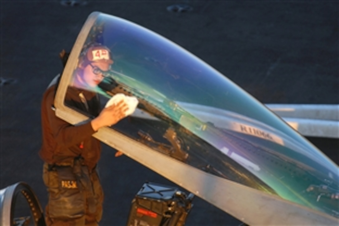 The sun reflects colors of the rainbow off the canopy of an F/A-18C Hornet as U.S. Navy Seaman Benjamin Olegario cleans it on the flight deck  of the aircraft carrier USS Ronald Reagan, under way in the Pacific Ocean, Nov. 3, 2008. Olegario is responsible for the aircraft until it is turned over to the pilot. 