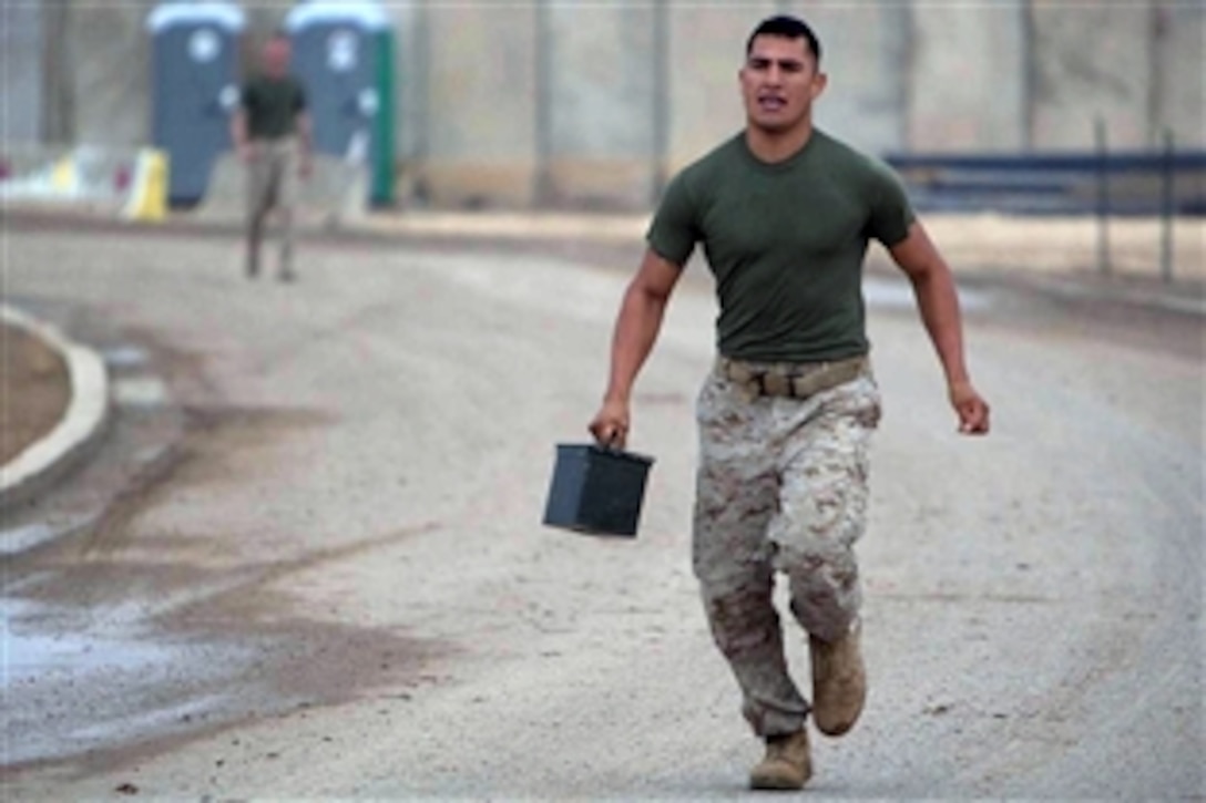 A U.S. Marine runs to the finish line with an ammo can in hand, at Camp Baharia, Iraq, Oct. 31, 2008. The Marines and Sailors from Charlie Company, 1st Battalion, 3rd Marine Regiment, Regimental Combat Team 1, are participating in the "Charlie Company Olympics," a physical and mental event that included ammo can runs, push-ups, mud crawls, weapons disassembly, and tests of their military knowledge.
