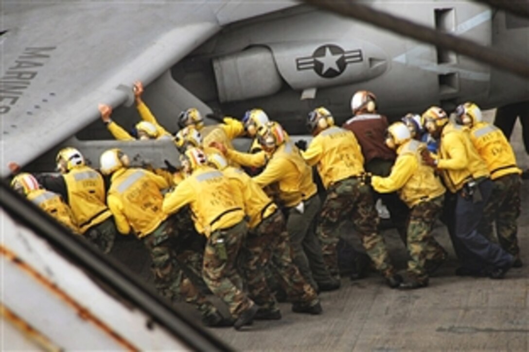 U.S. Navy seamen move an AV-8B Harrier II jet toward the aft elevator aboard the USS Boxer in the Pacific Ocean, Oct. 31, 2008. The USS Boxer is conducting an exercise in the Pacific Ocean to prepare for a deployment early next year.