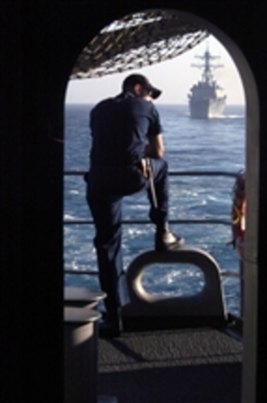 U.S. Navy Petty Officer 3rd Class Lance Reynolds stands on the fantail of the aircraft carrier USS John C. Stennis (CVN 74) as the USS Preble (DDG 88) follows astern during a simulated strait transit exercise in the Pacific Ocean on Oct. 29, 2008.  The John C. Stennis Carrier Strike Group is conducting a composite training unit exercise off the coast of southern California.  