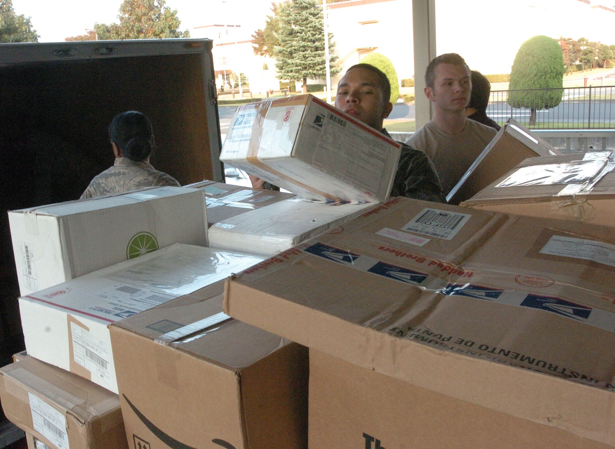 YOKOTA AIR BASE, Japan-- Senior Airman Harold Sorto, Detatchment 2, helps members of the 374th Communications Squadron unload mail and packages for the families of Yokota Air Base. The post office recieves an average of 2,500 packages a week. During the holidays, the packages are expected to double in number. Volunteers are always needed and can contact the Postmaster, MSgt Bruce Okazaki at 225-3957. (U.S. Air Force photo by Airman 1st Class Leandra D Hernandez) 