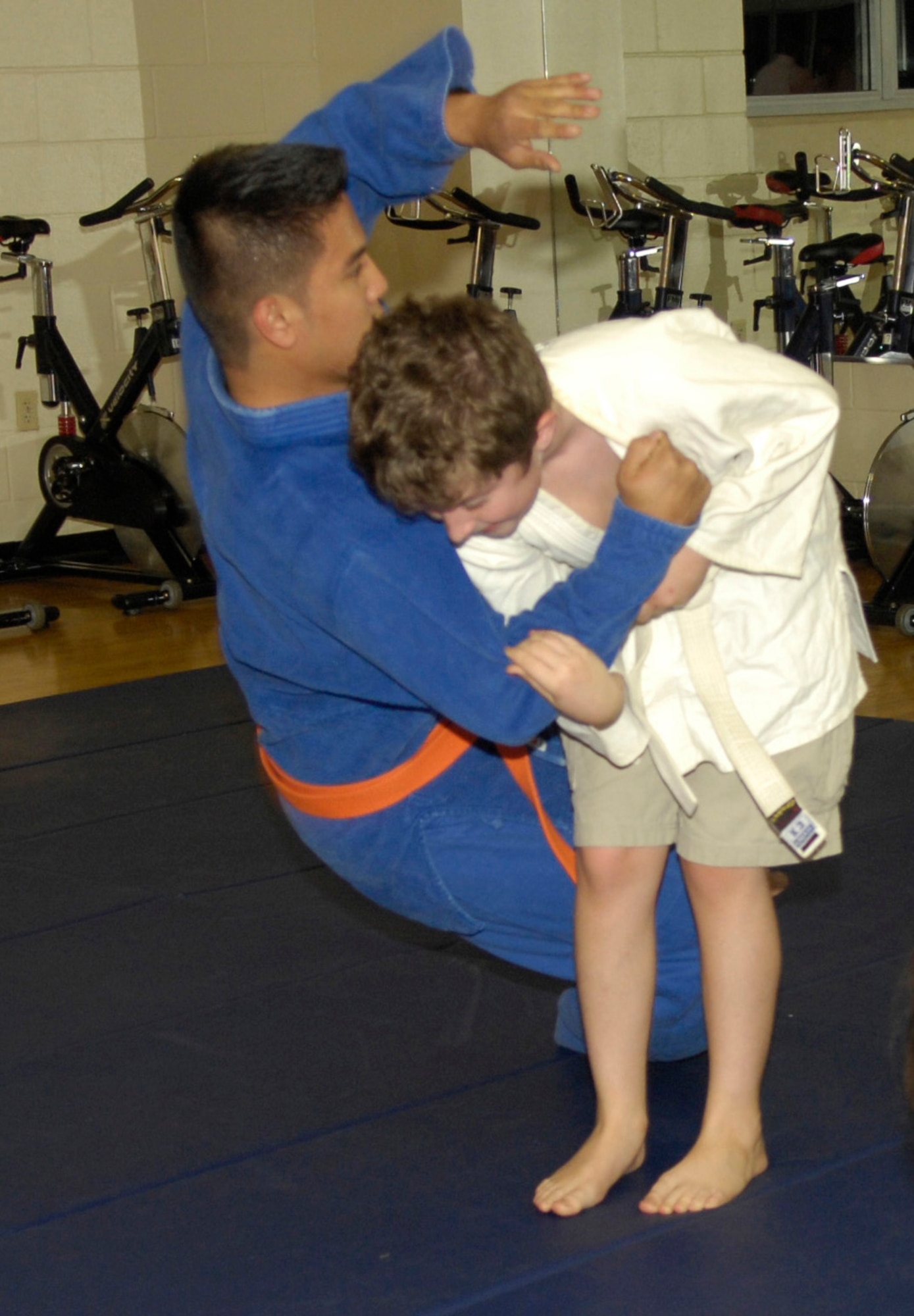 BARKSDALE AIR FORCE BASE, La. - Airmen 1st Class EJ Dino, 2d Aircraft Maintenance Squadron, gets thrown during a Judo move by Brandon Cox, age 10, from Princeton Elementary School.  Judo is a form of self- defense.  It takes place at the Fitness Center on Tuesdays for juniors starting at 6 p.m., and Thursdays for seniors starting at 7 p.m.  (Air Force photo by Senior Airman Alexandra Sandoval) (Released)