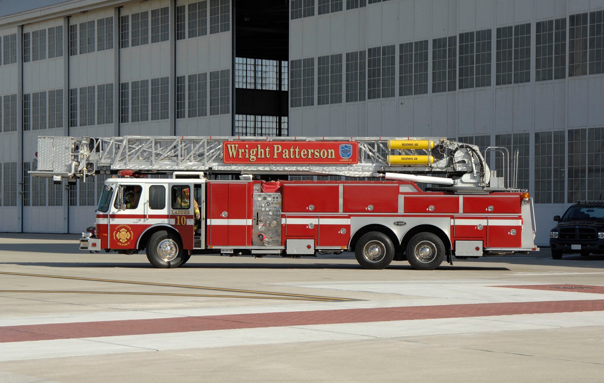 Wright-Patterson Air Force Base firefighters arrrive with Ladder 10 to rescue air traffic controllers "trapped" in the tower due to a fire in Building 206.  The Nov. 4 training exercise familiarized firefighters and control tower personnel with rescue procedures using the department's 95-foot aerial platform ladder truck. (U.S. Air Force photo/William Pugh)