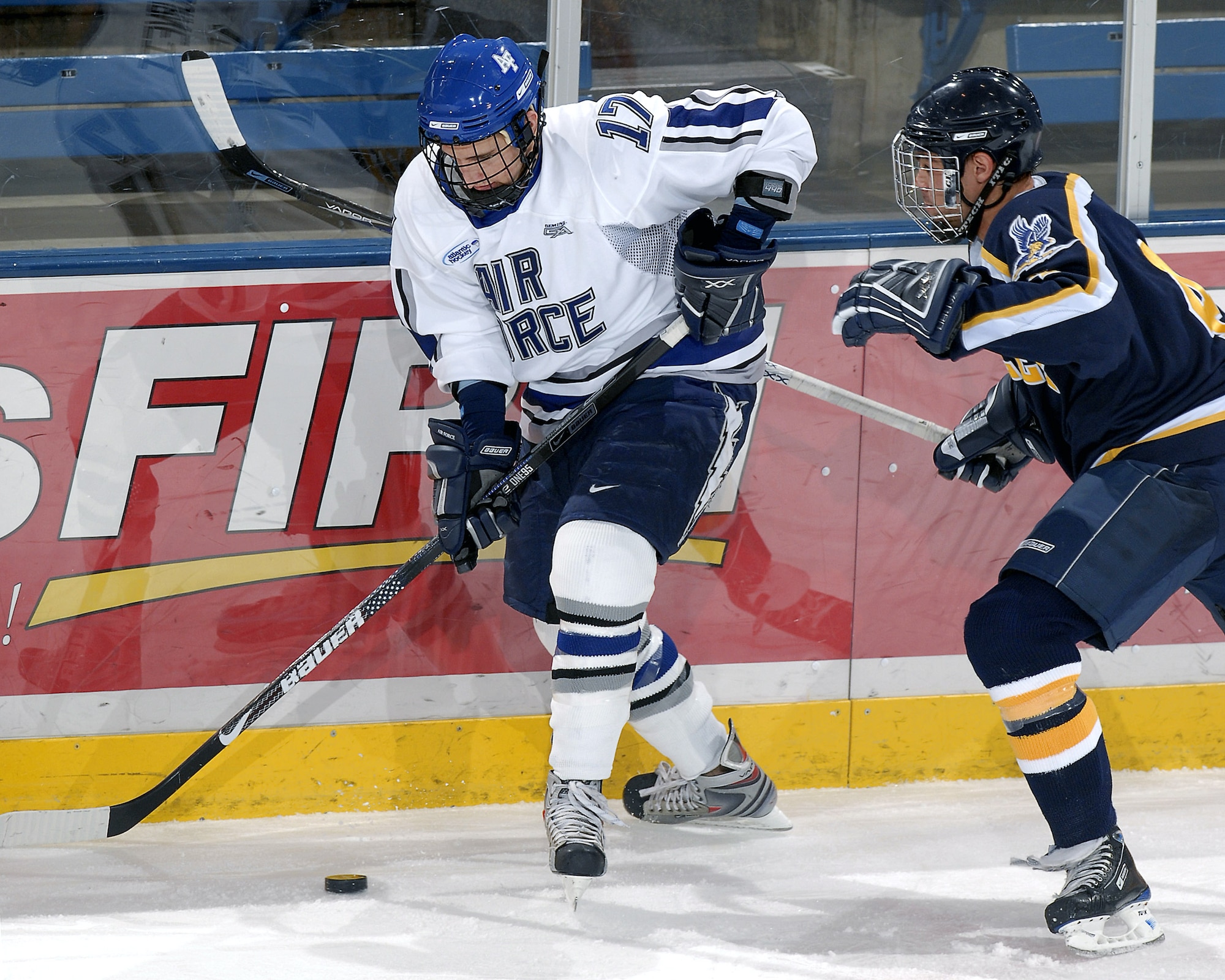 Air Force Academy forward Derrick Burnett works the puck around a Bentley College defender during action Oct. 31 at the Academy's Cadet Ice Arena in Colorado Springs, Colo.  Air Force went on to defeat Bentley 5-1.  The next evening, the Academy skaters defeated Bentley 8-2, giving them a perfect 8-0 start, which ties a school record set in 1971-72. Air Force currently is ranked 14th in the nation.  (U.S. Air Force photo/Mike Kaplan)