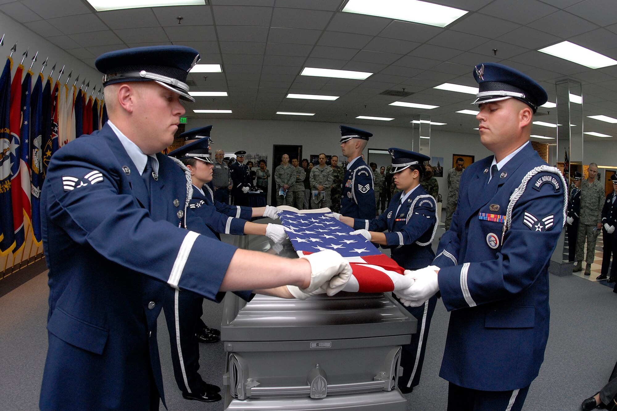 Senior Airmen Justin Alexander and Vincente Martinez, Airman 1st Class Keri Mattingly, Airman Audrey Steckman and Staff Sgt. Charles Pope, of the High Frontier Honor Guard, demonstrate a funeral flag folding ceremony in the new Honor Guard facility Oct. 10. (Air Force photo/Rob Bussard)