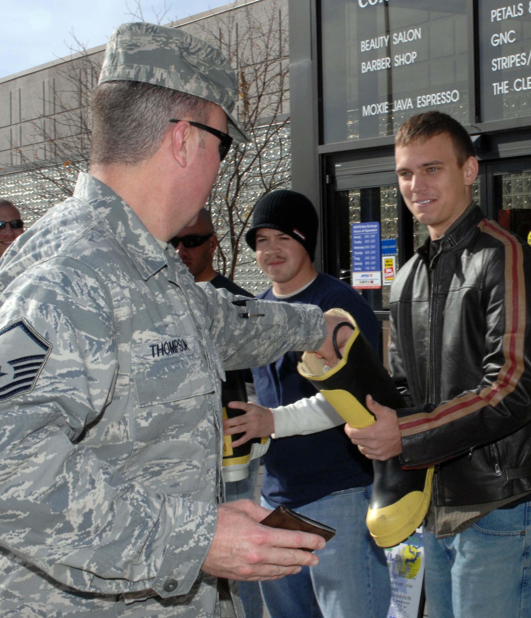 MOUNTAIN HOME AIR FORCE BASE, Idaho -- Senior Airman Steven Bency, 366th Civil Engineer Squadron fire emergency services flight, collects money from Master Sgt. James Thompson, 366th Aircraft Maintenance Squadron, for a family that lost their home in a fire Oct. 27. In the three hours the fire emergency services flight was collecting donations, the Gunfighters contributed more than $2,050 to the family. To make a donation to the family, call Tech. Sgt. Dyan Christian at 828-6527. (U.S. Air Force photo/ Airman 1st Class Ashley Tank)