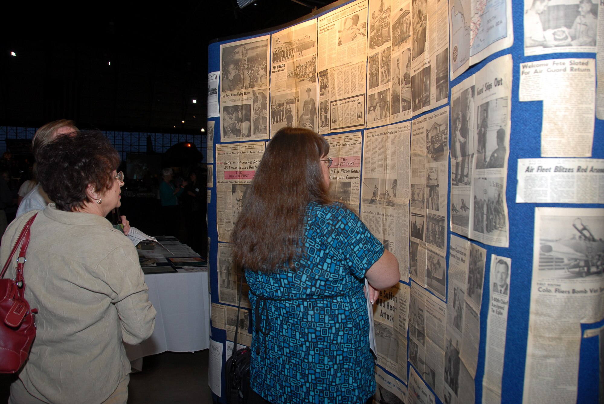 Former 140th Wing members at the '68 Call Up Reunion read 1968 historical news clippings detailing the 900-member mobilization of the Colorado Air National Guard.