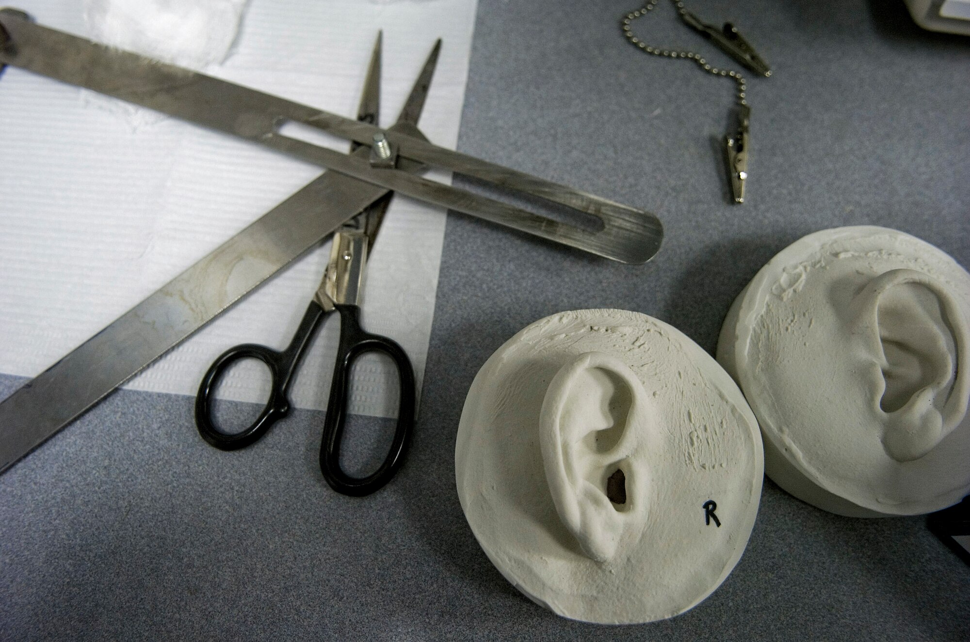 A 3-D model resin prosthesis mold of ears and tools lie on a table at the McGowan Dental Clinic Sept. 29 at Lackland Air Force Base, Texas. Maxillofacial prosthodontists of the 59th Medical Wing create ears, eyes and noses for military members that have been injured during duty. (U.S. Air Force photo/Staff Sgt. Desiree N. Palacios)

