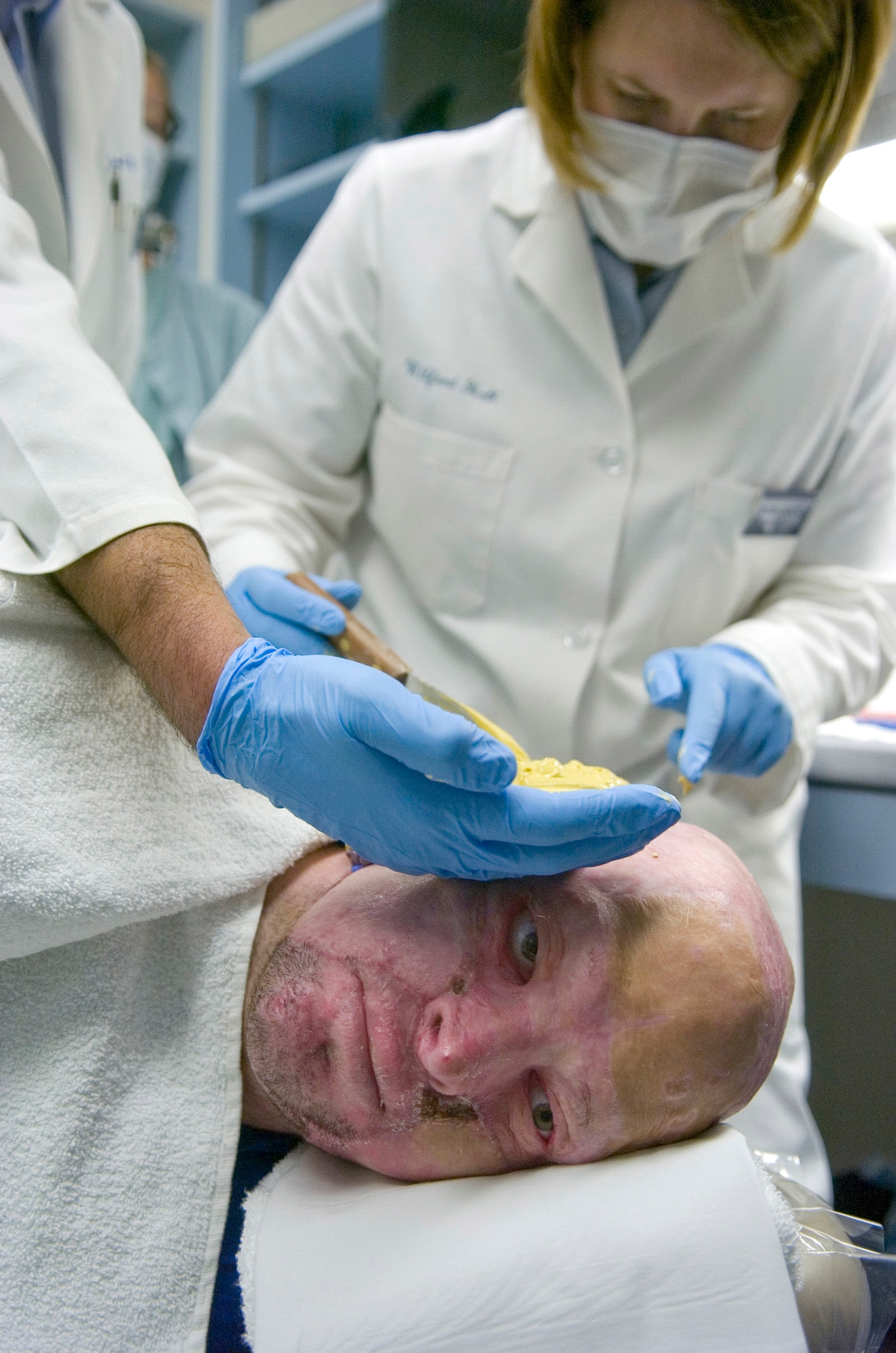 Capt. (Dr.) Angela Stanton (right) and Col. (Dr.) Joe Villalobos (left) create a 3-D model resin prosthesis mold for Marine Capt. Ryan Voltin at the McGowan Dental Clinic Sept. 29 at Lackland Air Force Base, Texas. Captain Voltin, an AH-1 Cobra pilot, lost his ears when his helicopter erupted in flames during a training accident in May 2007. Dr. Stanton and Dr. Villalobos are fellow maxillofacial prosthodontists assigned to the 59th Medical Wing. (U.S. Air Force photo/Staff Sgt. Desiree N. Palacios)
