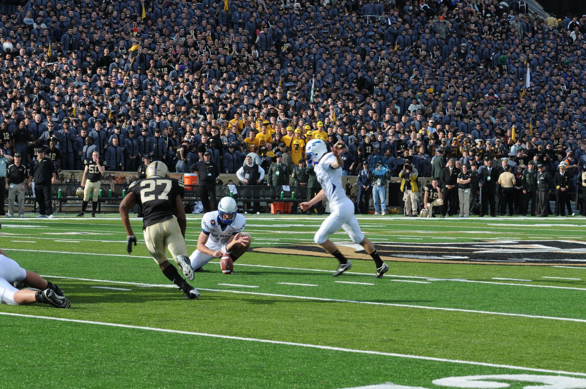Air Force Falcon Ryan Harrison concentrates on kicking the ball, while blocking out the image of Army defensive back Jean-Pierre Cooper, who was charging him during the annual Air Force/Army game Nov. 1 in West Point, N.Y. The 16-7 win kept the Air Force on track for bowl eligibility. (Photo courtesy of Kimberly Peterson)