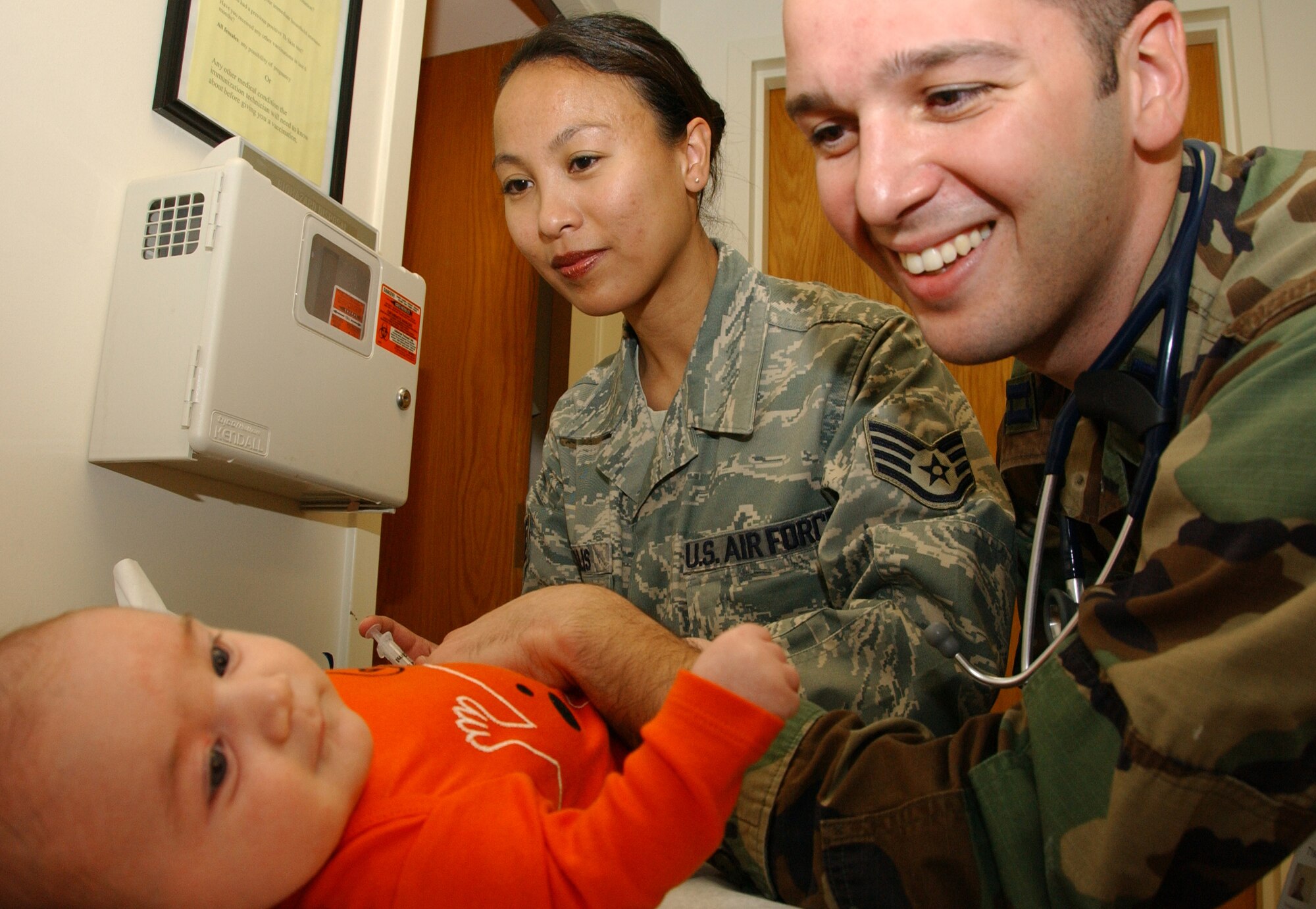 Staff Sgt. Lorylee Willis, 71st Medical Group immunizations technician, injects Pediarix into two-month old Sophia Grace Pellegrino, as her father, Dr. (Capt.) Peter Pelligrino, 71st MDG pediatrician, looks on. Padiarix is one of three shots (plus one oral immunization) given at the two-month clinic visit. (U.S. Air Force photo by Staff Sgt. Brian Hill)