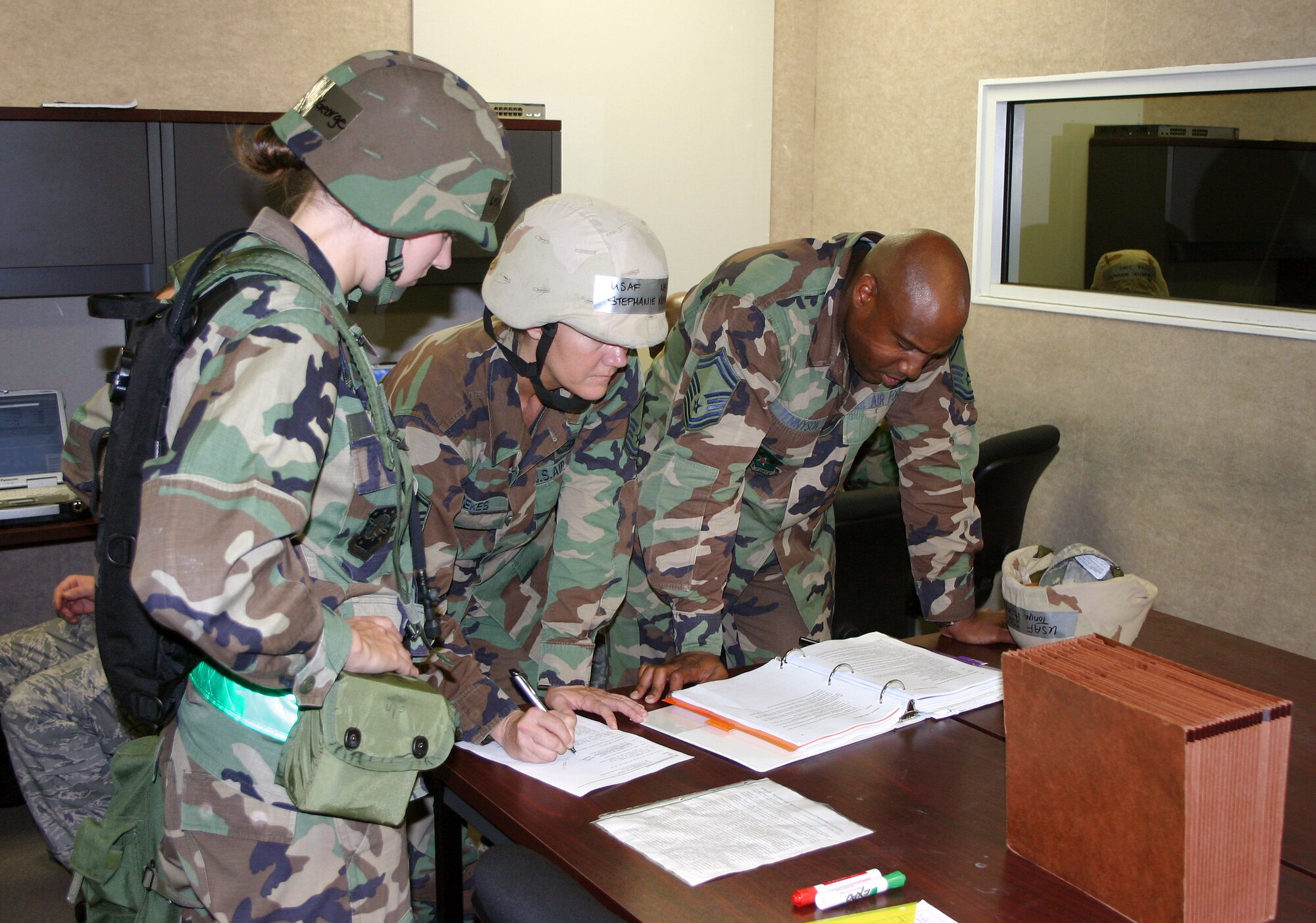 2nd Lt. Melissa George, Master Sgt. Stephanie Kerekes and Senior Master Sgt. Nate Tennyson review casualty procedures during a Silver Flag exercise Nov. 2 at Tyndall Air Force Base, Fla. (U.S. Air Force photo/Richard Salomon) 
