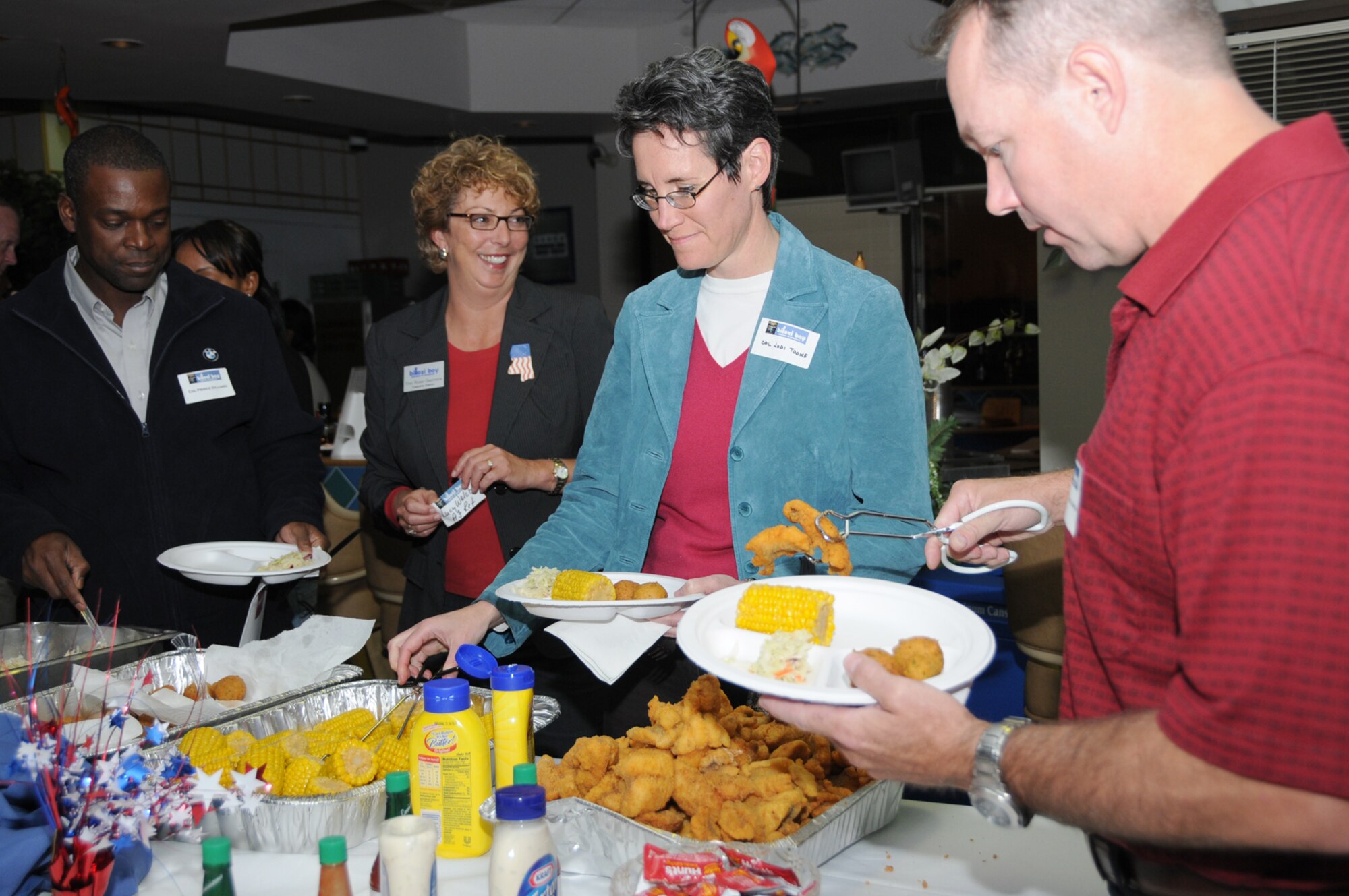 From left, Col. Prince Gilliard, 81st Training Group commander; Tina Ross-Seamans, Biloxi Bay Chamber of Commerce executive director; Col. Jodi Tooke from Scott Air Force Base, Ill., Air Force Cyber Command (Provisional); and Maj. Scott Solomon, 333rd Training Squadron commander,  mingle at the Scope Warrior fish fry, Oct. 27 at the Katrina Kantina.  (U.S. Air Force photo by Kemberly Groue)
