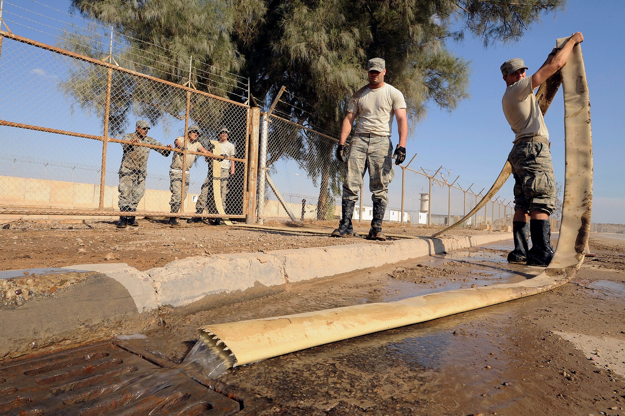 Airman 1st Class Gregory Hayes (right) drains a hose as other Airmen from the 332nd Expeditionary Civil Engineer Squadron watch Nov. 3 at Joint Base Balad, Iraq. The Airmen are utility system technicians with the 332nd Expeditionary Civil Engineer Squadron. Airman Hayes, a native of Lancaster, S.C., is deployed from Schriever Air Force Base, Colo. (U.S. Air Force photo/Airman 1st Class Jason Epley) 
