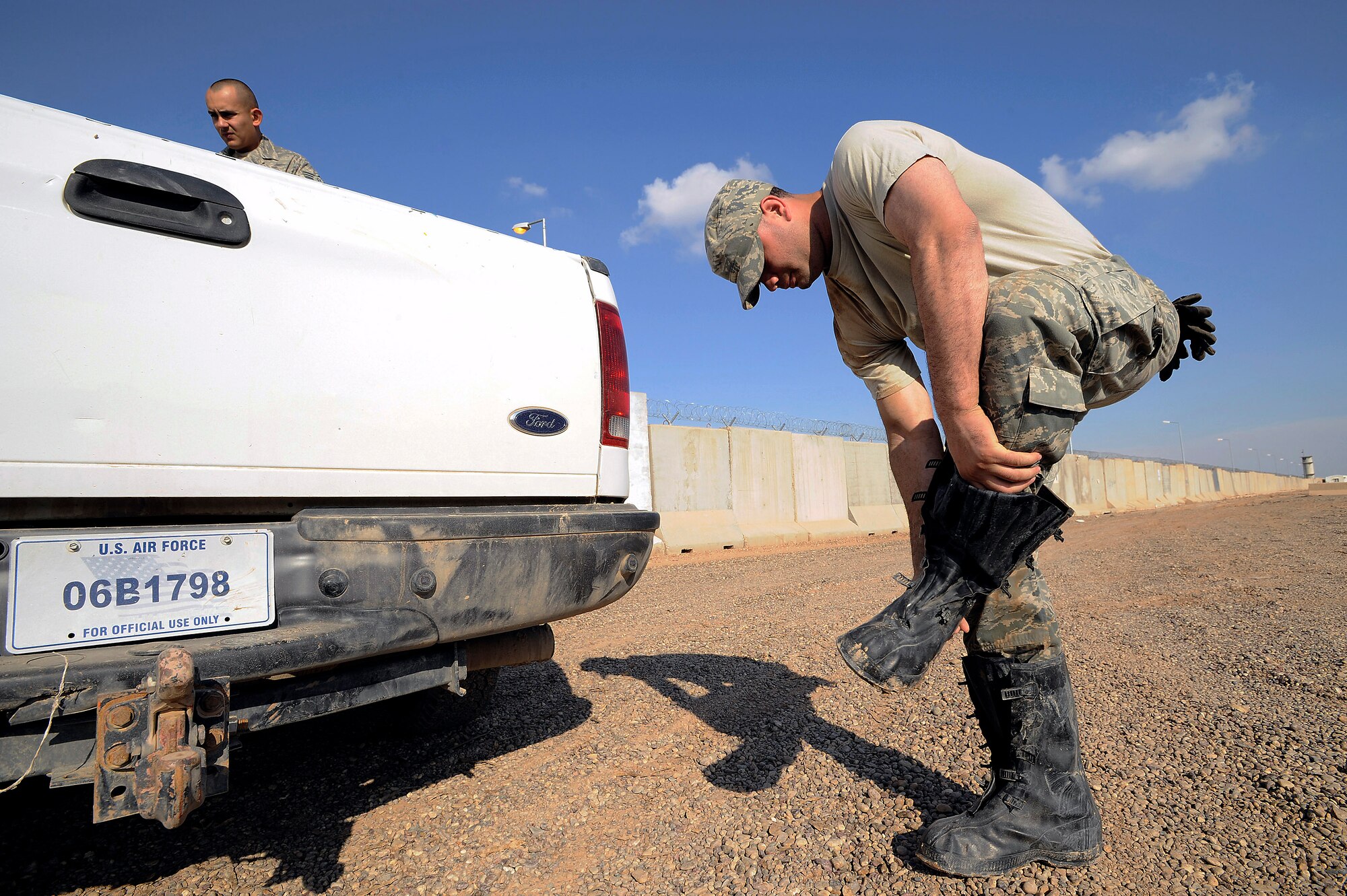 Senior Airman Paul Clayborn removes rubber boots after pumping floodwater into an unused yard Nov. 3 at Joint Base Balad, Iraq. Airman Clayborn, a utility system journeyman with the 332nd Expeditionary Civil Engineer Squadron, is deployed from Andrews Air Force Base, Md. His hometown is Arlington, Texas. (U.S. Air Force photo/Airman 1st Class Jason Epley) 
