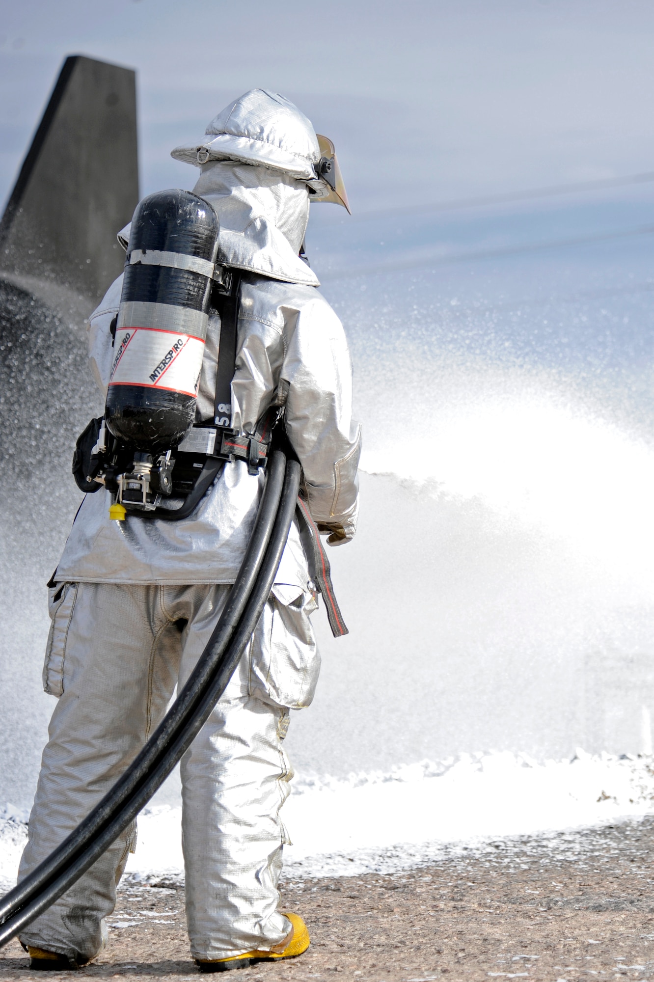 Billy Cina, 28th Civil Engineer Squadron fire department driver and operator, sprays foam on a pit fire here, Nov. 4.  A new compressed air foam modified prototype valve was installed on an Ellsworth fire truck for testing. The new system is being tested at Ellsworth due to its cold climate. (U.S. Air Force photo/Airman Matthew Flynn)