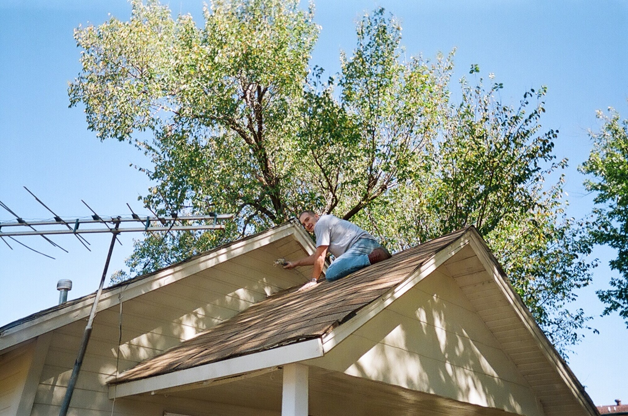 Lt. Col. Ted Guetig of the 32nd Flying Training Squadron at Vance Air Force Base paints the hard to get spots atop a local veteran's home as part of the "Christmas in Action" program. (Courtesy photo)
