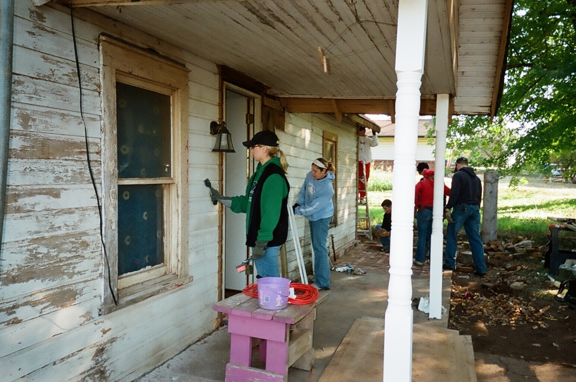 Capt. Tara Erlandson and Capt. Katie McGregor (left to right) of the 32nd Flying Training Squadron prepare a house for paint as part of a Christmas in Action team Oct. 25. (Courtesy photo)
 