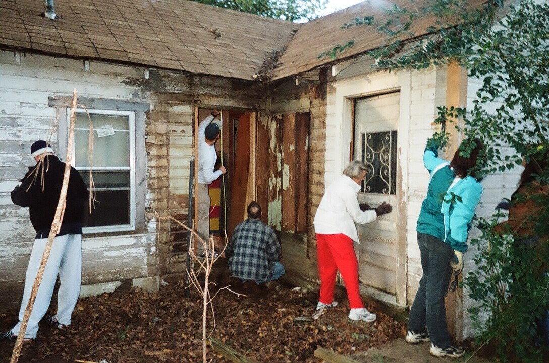 Lt. Col. Ted Guetig and 1st Lt. Sam McAnally (center) of the 32 Flying Training Squadron repair an exterior wall of a local veteran's home, while other local volunteers paint and scrape. (Courtesy photo)