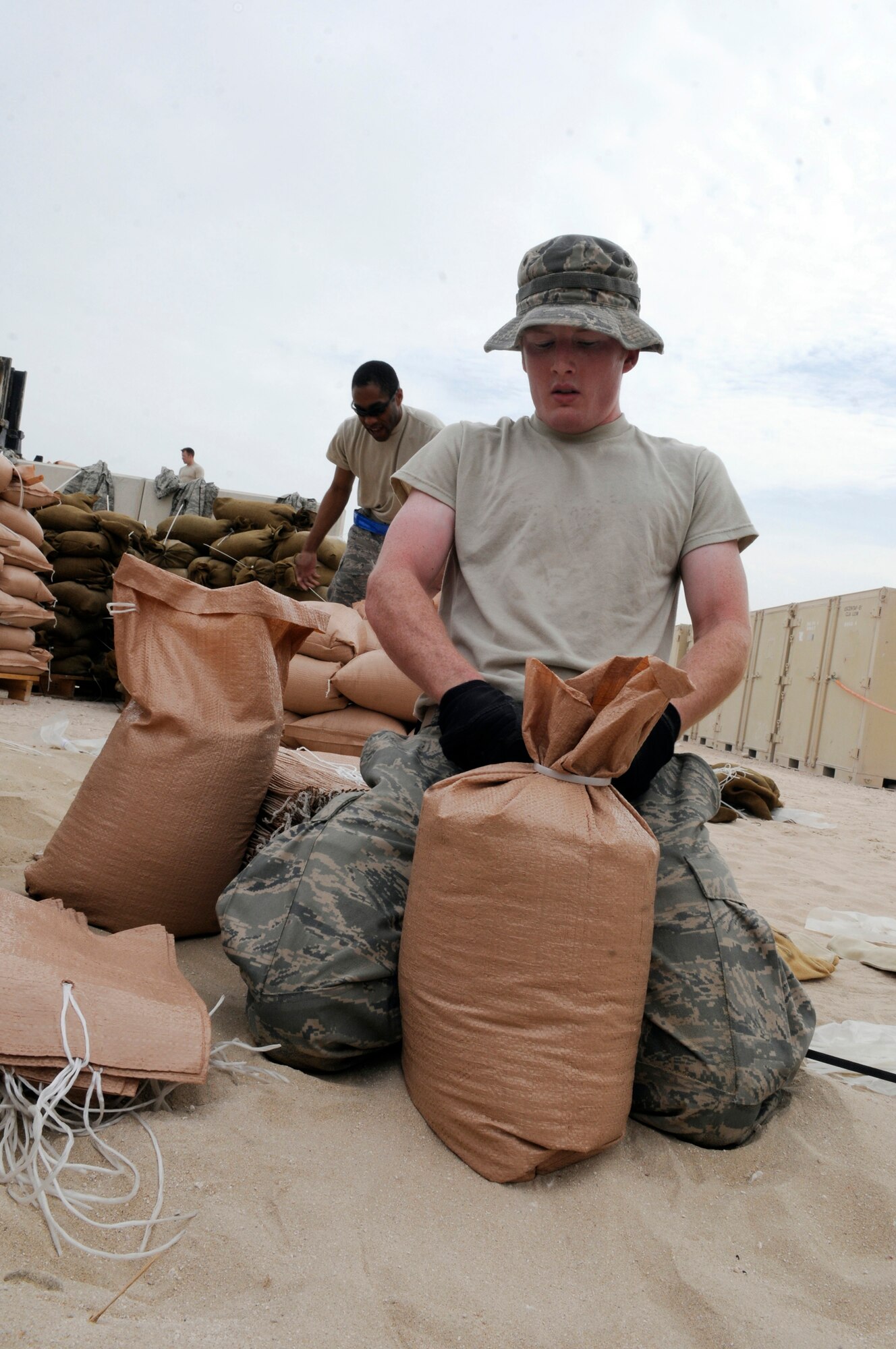 Senior Airman Kyle Edwards, assigned to the 379th Expeditionary Communications Squadron, uses zip ties to close sand bags Nov. 4, at an undisclosed air base in Southwest Asia.  The sandbags will be used to fortify emergency bunkers.  Airman Edwards, hailing from Stanwood, Wash., is deployed from Robins Air Force Base, Ga., in support of Operations Iraqi and Enduring Freedom and Joint Task Force-Horn of Africa.  (U.S. Air Force photo by Tech. Sgt. Michael Boquette/Released)