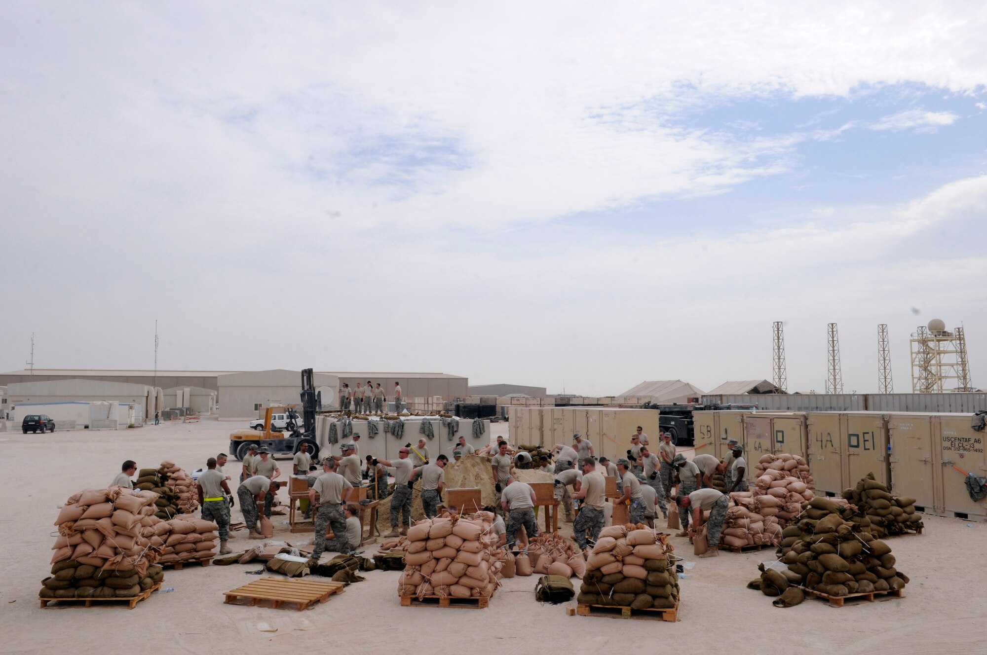 The personnel of the 379th Expeditionary Communications Squadron work as a team to fill sandbags Nov. 4, at an undisclosed air base in Southwest Asia. The sandbags will be used to fortify emergency bunkers in support of Operations Iraqi and Enduring Freedom and Joint Task Force-Horn of Africa.  (U.S. Air Force photo by Tech. Sgt. Michael Boquette/Released)