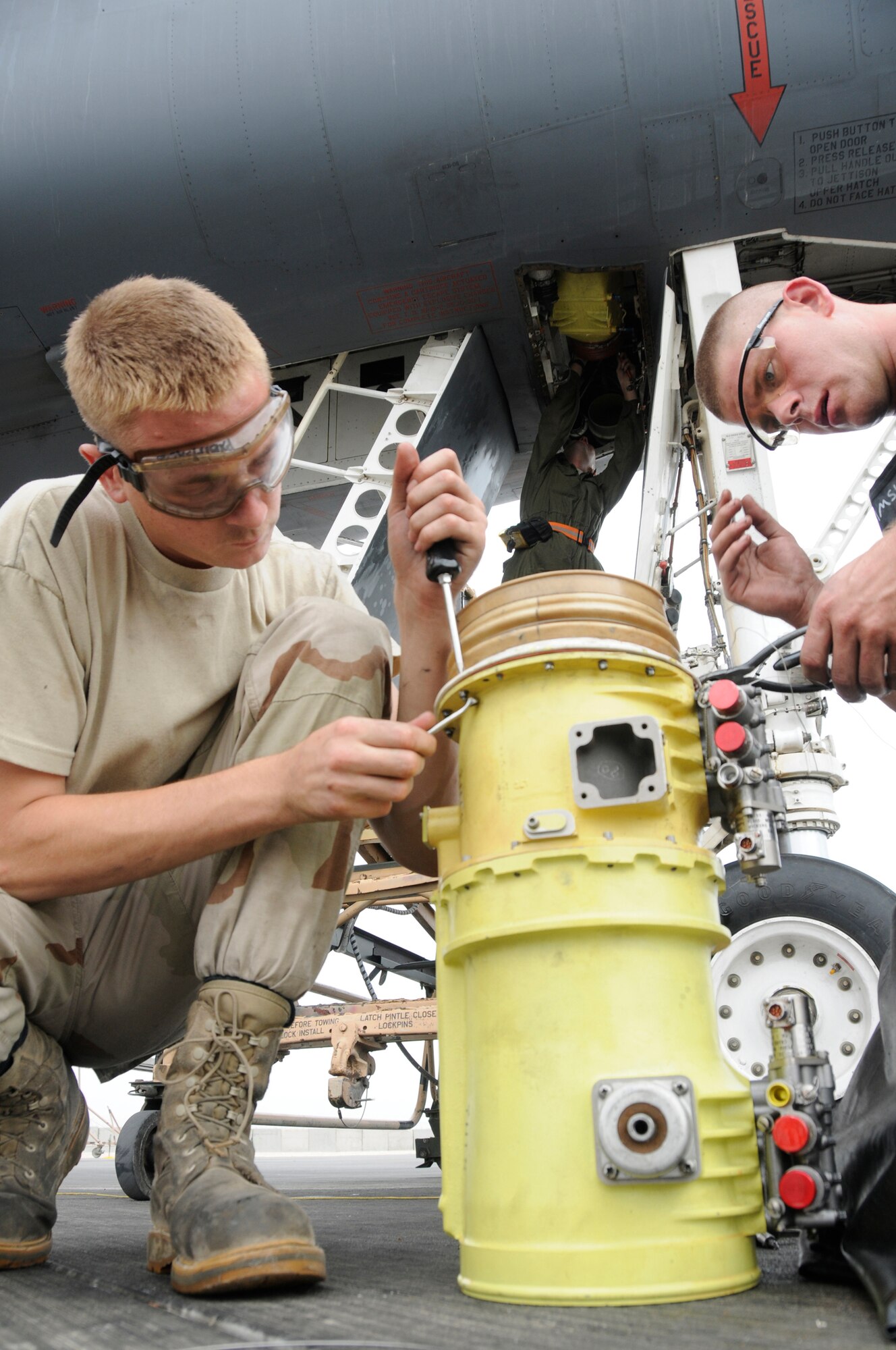 Airman 1st Class Kyle Stinger tightens screws while Senior Airman David Wonsitle applies safety wire to a B-1B Lancer air recirculation loop blower Nov. 4, at an undisclosed air base in Southwest Asia.  Both are aircraft electrical and environmental journeymen assigned to the 379th Expeditionary Aircraft Maintenance Squadron, deployed from Ellsworth Air Force Base, S.D., in support of Operations Iraqi and Enduring Freedom.  Airman Stinger is a native of St. Louis, Mo., and Airman Wonsitle hails from Abilene, Texas.  (U.S. Air Force photo by Staff Sgt. Darnell T. Cannady/Released)
