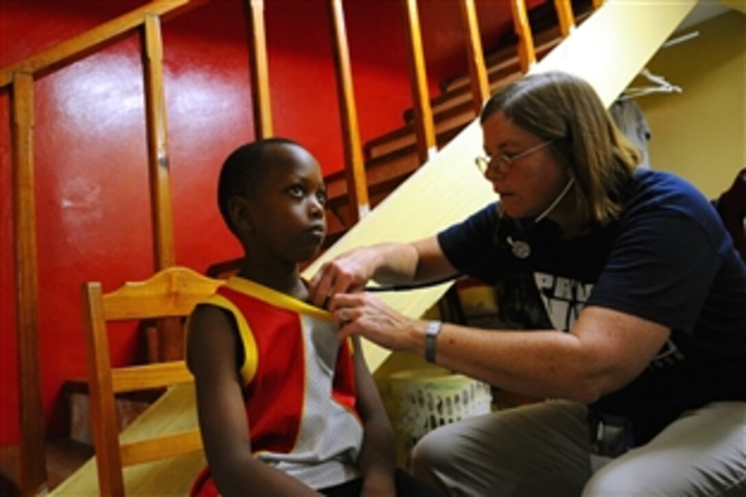 Project HOPE volunteer Anne Gadomski, embarked aboard the amphibious assault ship USS Kearsarge, examines a child at the Phillips Children Home during a medical clinic as part of the Caribbean phase of the humanitarian/civic assistance mission Continuing Promise 2008, Oct. 30, 2008. 