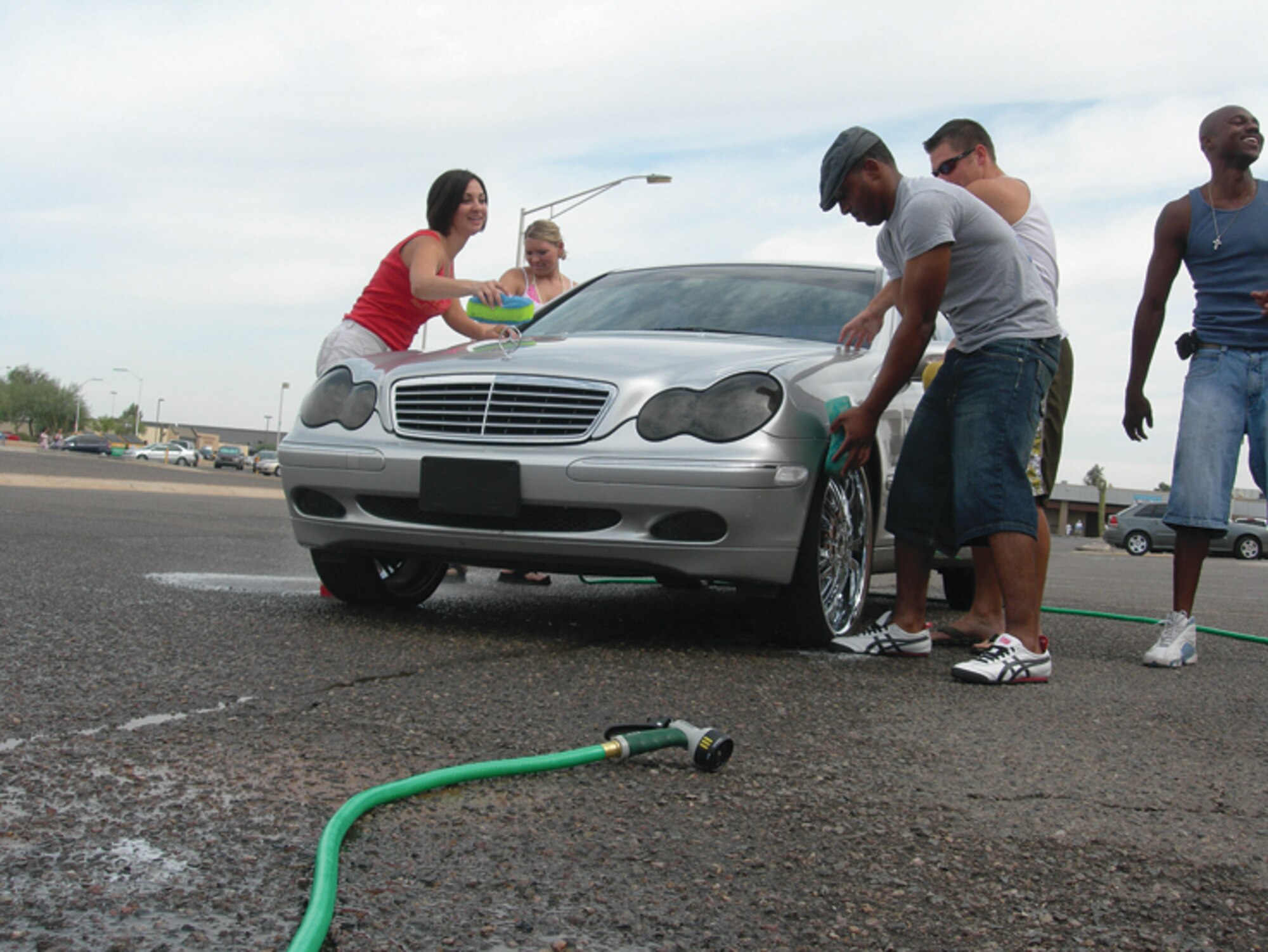 56th Operations Support Squadron morale committee members wash cars at the base theather parking lot Oct. 3 to raise money for a squadron member who is hospitilized and morale functions in general. (U.S. Air Force photo/ Senior Airman Tong Duong.)